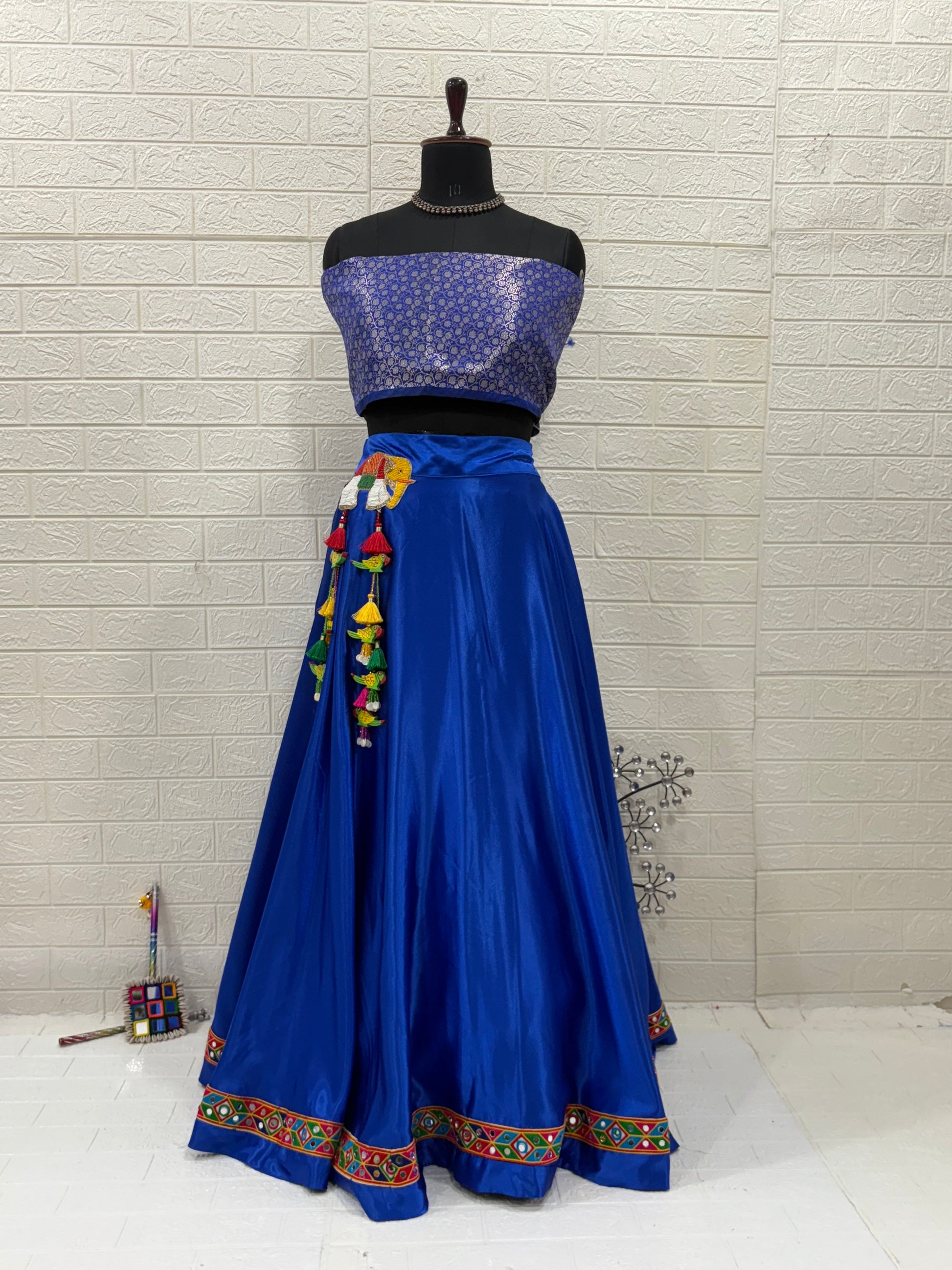 Name: Royal Blue Lehenga & Dupatta A vibrant royal blue crafted in soft pure synthetic satin Lehenga with patchwork,brocade blouse with mirror work Bandhni Dupatta and sequin lace, perfect for festive celebrations.