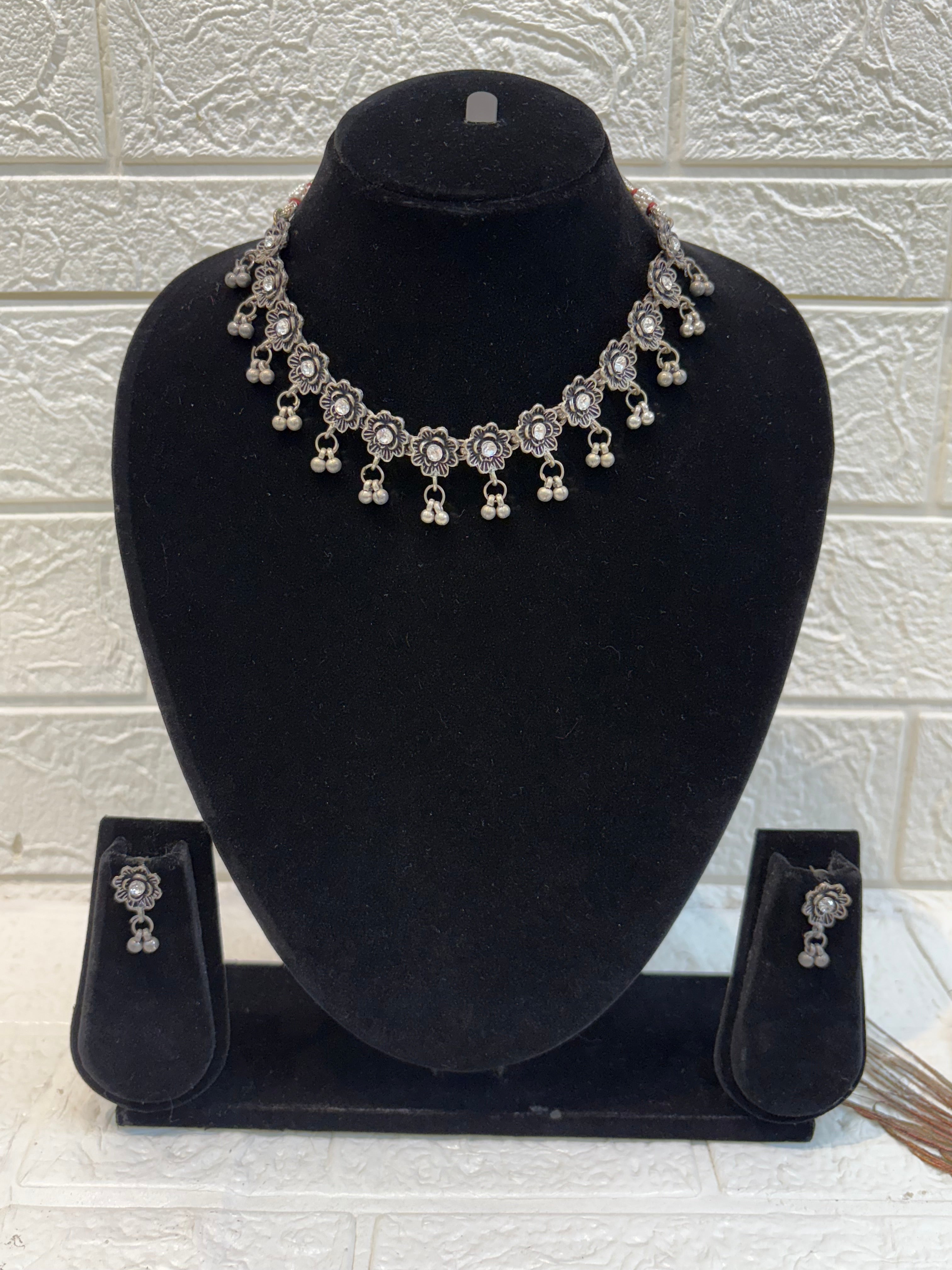 Name: Floral Oxidized Silver Necklace Set Crafted in German silver with antique finish and dangling bead accents