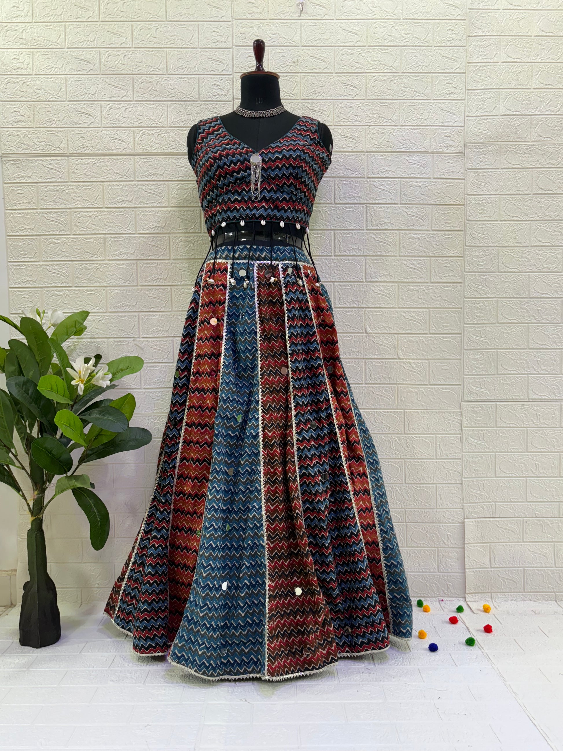 Name: Multi-Color Chevron Lehenga Set Made from lightweight pure cotton blend with chevron print panels, mirror accents, and a stitch sleeveless blouse with  cowrie shell in blouse – perfect for Navratri and festive garba nights.