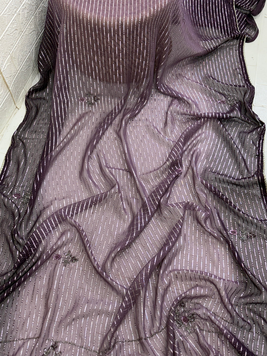 Purple Wine Saree fabric This is a lightweight Organza or Georgette Saree featuring silver Zari (metallic) stripes woven throughout and floral thread/sequin embroidery.
