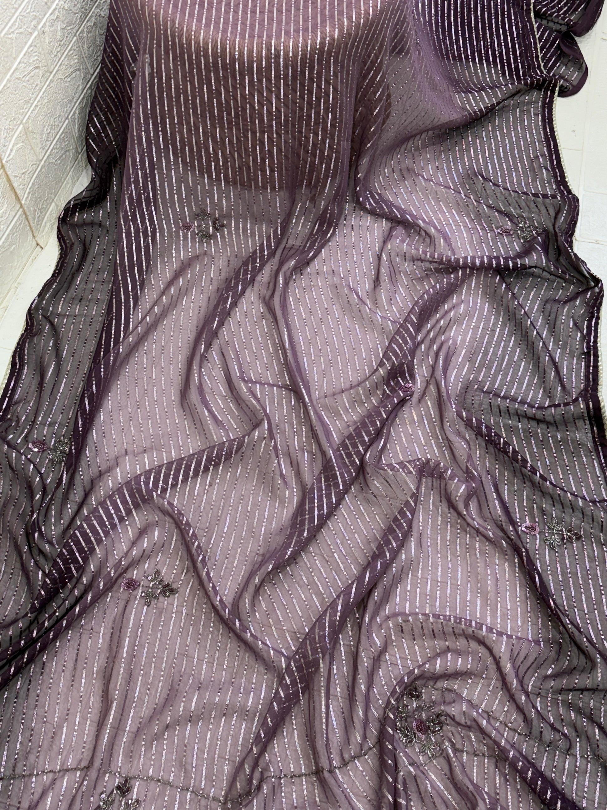 Purple Wine Saree fabric This is a lightweight Organza or Georgette Saree featuring silver Zari (metallic) stripes woven throughout and floral thread/sequin embroidery.