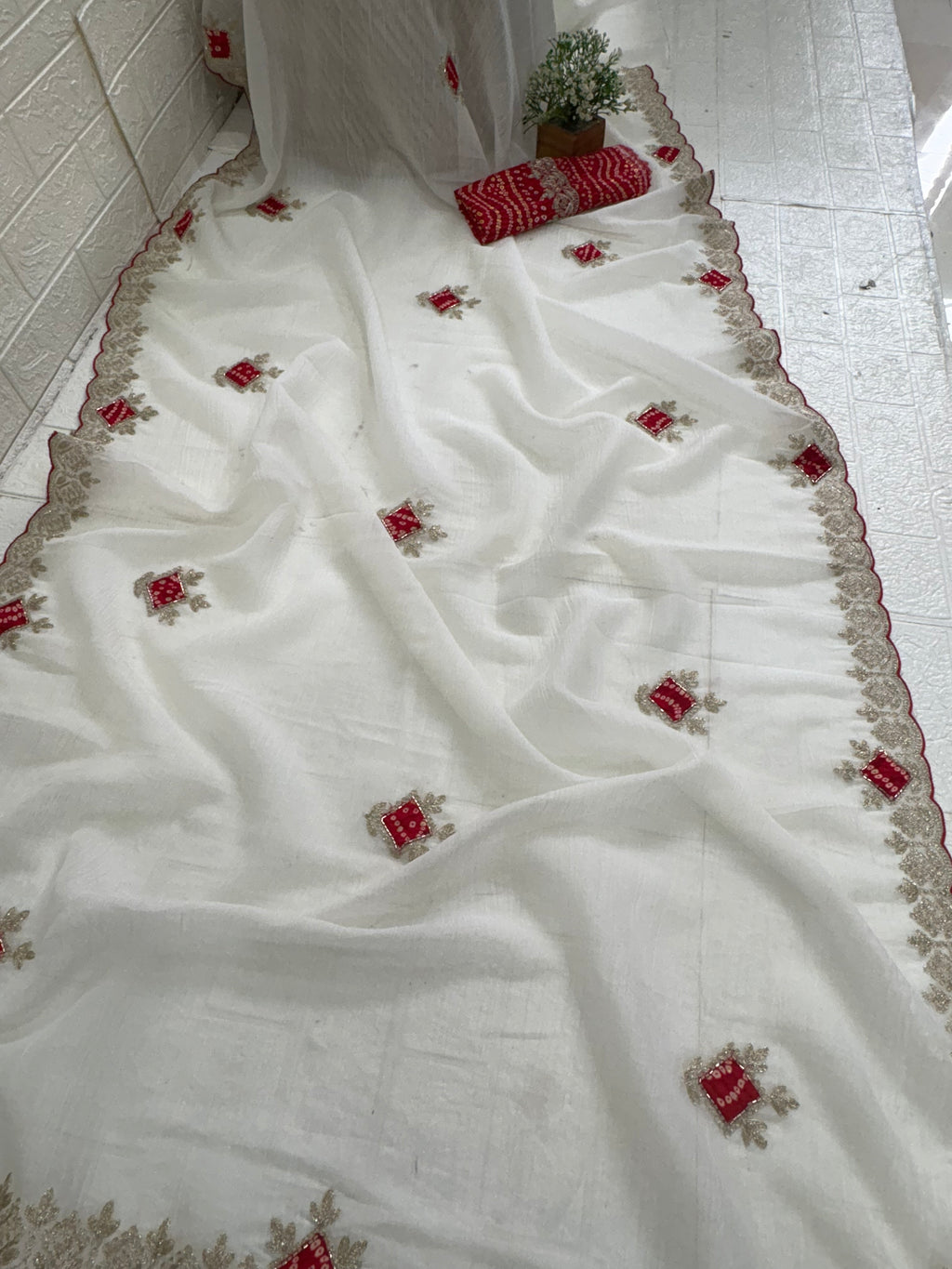 Name: Ivory Grace saree 
Elegant crush chinon fabric saree with red bandhej-style motifs and zari embroidered border. Bandhni-style blause fabric