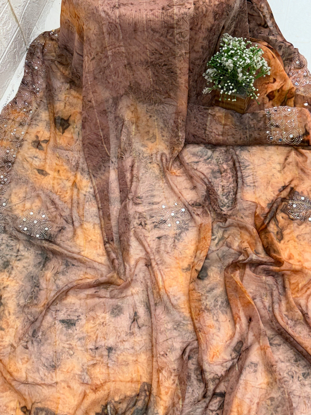 Saree with Woven mirror or peach and light black colour small motif The pattern is a  (motif) woven the sheer georgette fabric Silk.  with mirror work in saree This fabric is known for its sheer, lightweight texture