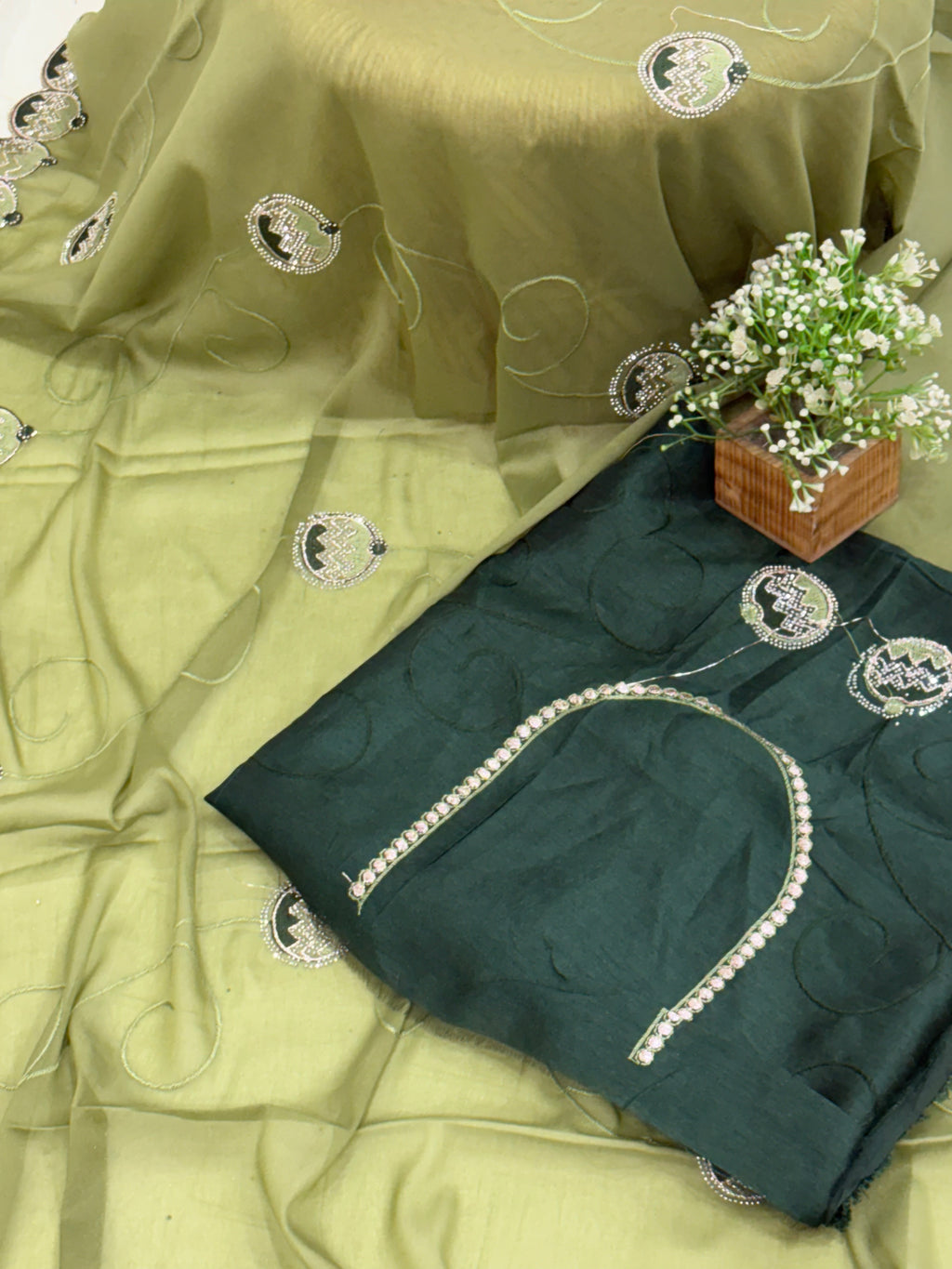 Saree georgette or organza and light mehndi green colour embroidered medallion butti and saree with scalloped border it is a sheer saree with scattered embroider and stonework