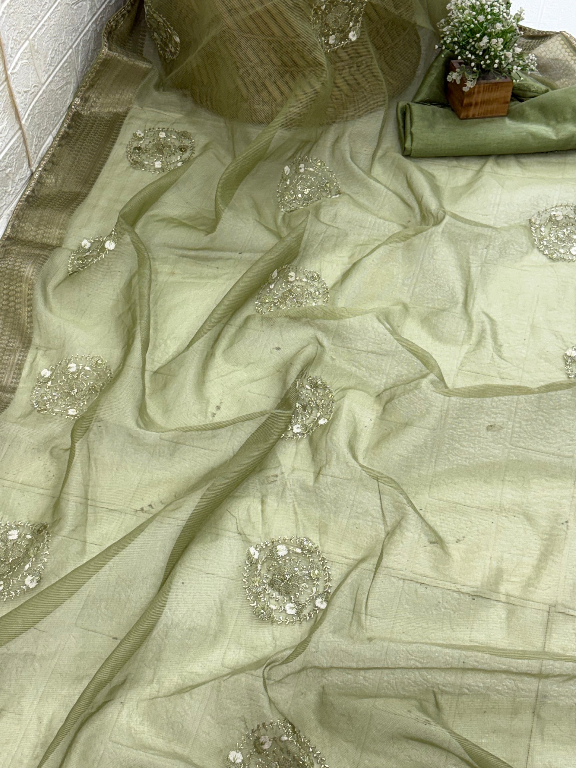 The fabric Khadi Cotton Silk Saree or a Cotton Silk its Olive Green or Sage Green color, a prominent woven zari (metallic) border and decorative thread embroidery work on the pallu