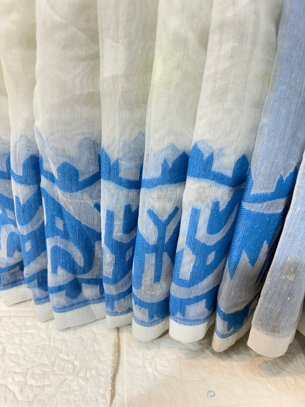 Neel Pushp Jamdani Saree
Crafted in soft cotton Jamdani, featuring a serene white body with delicate buti work and a rich blue woven border for an elegant, airy look.