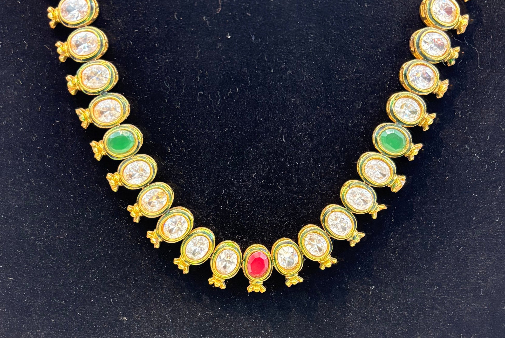 Elegant antique-finish necklace featuring oval-cut white stones highlighted with ruby and emerald accents, offering a classic and graceful look for festive and wedding wear.