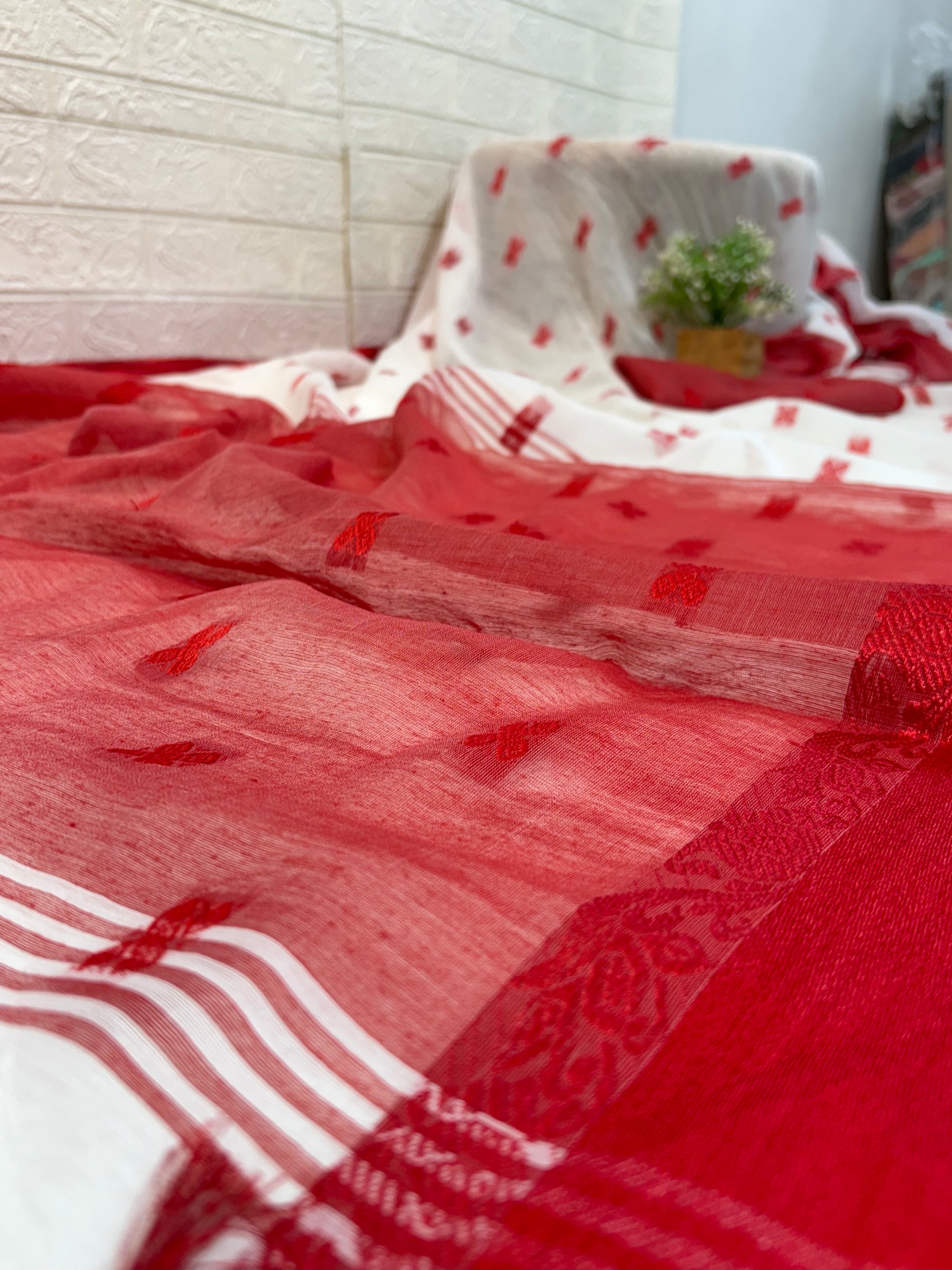 Cotton Jamdani Saree
Made from soft cotton Jamdani, featuring an elegant off-white body with red woven butis and a rich maroon-red border for a classic, graceful look.