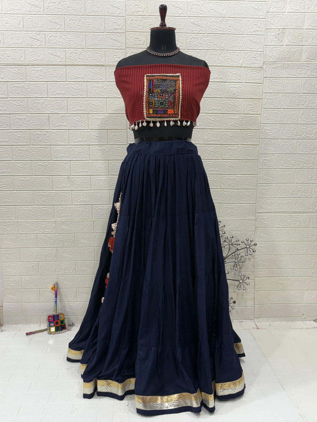 Name: Navy Blue Elegance Lehenga Made With soft cotton flair in deep navy, paired  with a maroon Ajrakh printed and patch blouse for a perfect ethnic fusion look