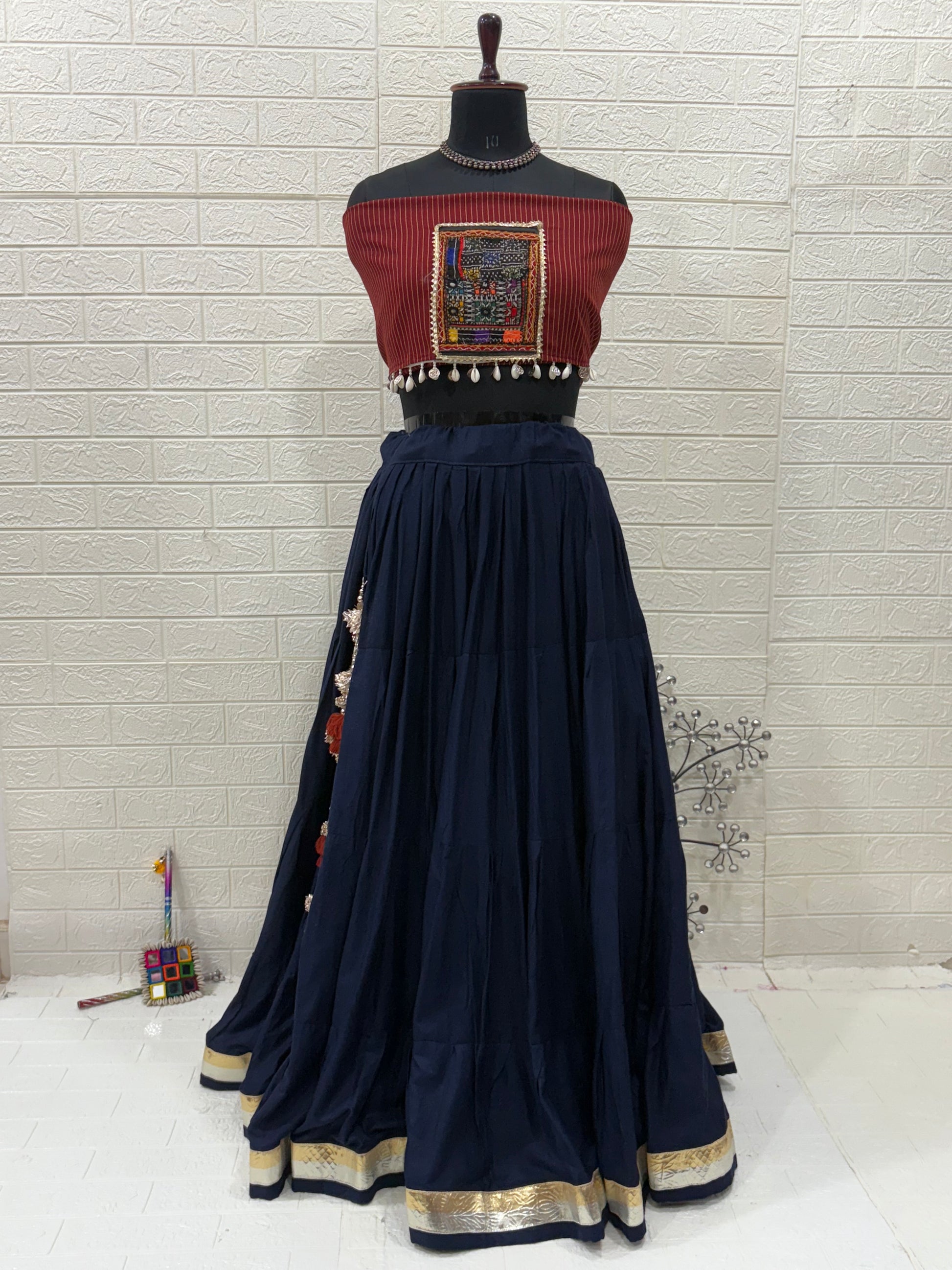 Name: Navy Blue Elegance Lehenga Made With soft cotton flair in deep navy, paired  with a maroon Ajrakh printed and patch blouse for a perfect ethnic fusion look