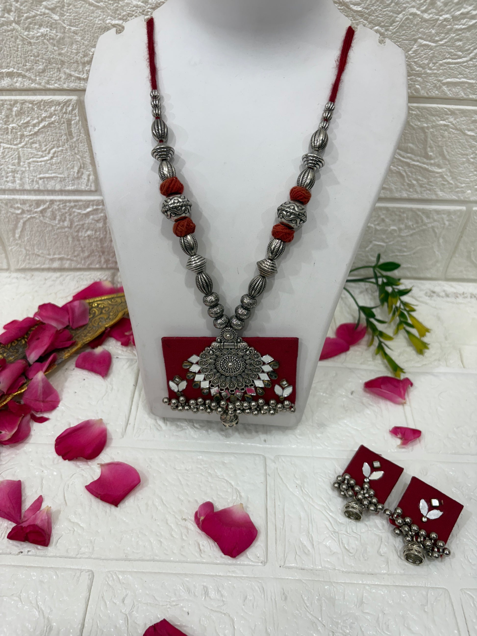 Name:
Red Fabric Pendant Necklace Set with Oxidized Silver Beads & Mirror Work

Collection:
Boho Oxidized Jewelry Collection
(or if you want a festive vibe: Navratri Special Fabric Jewelry Collection)