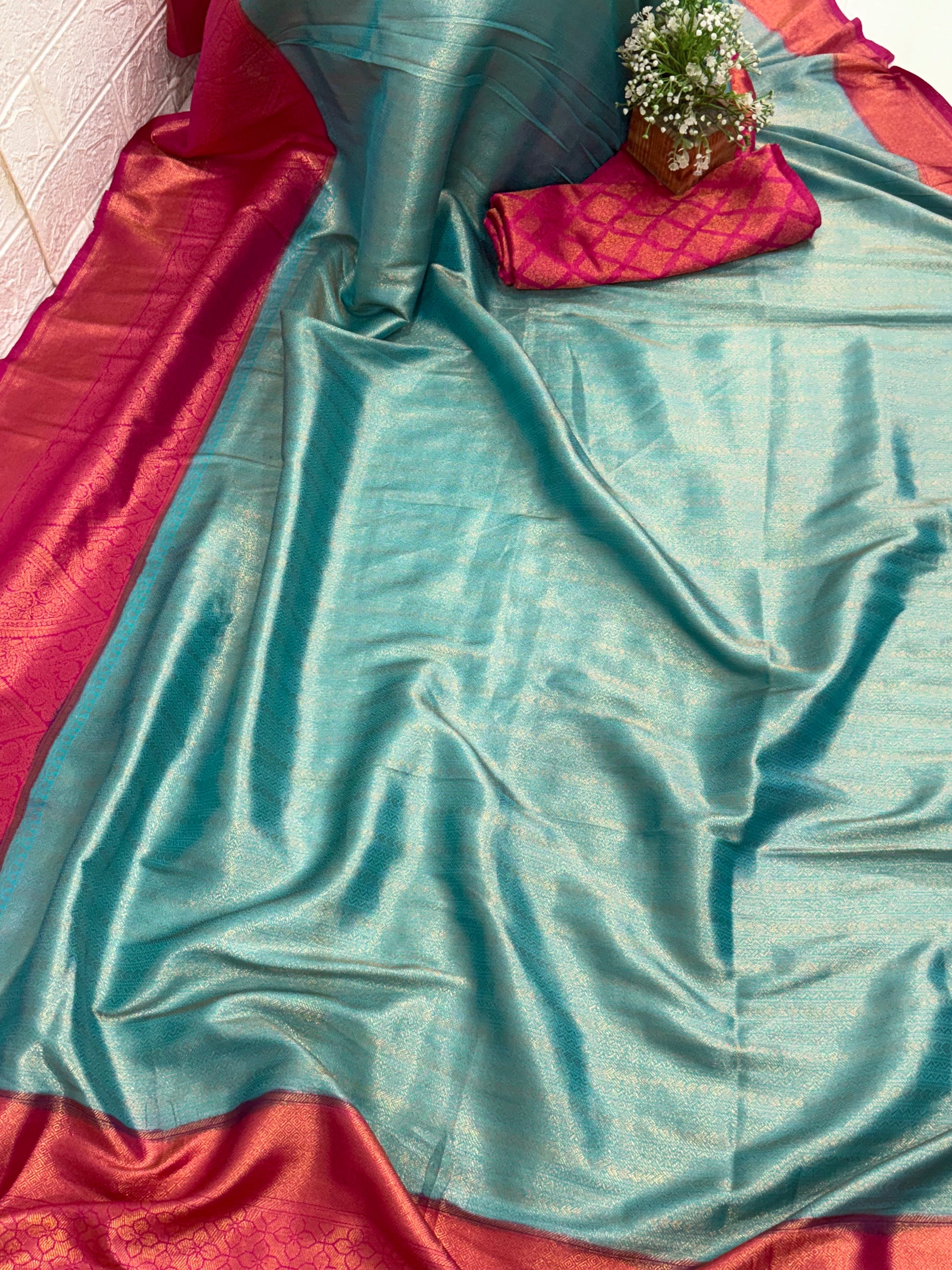 Kanchipuram Silk  (Silk Blend) A traditional dual-panel fabric, featuring a shot-effect reddish-pink and  golden top with woven motifs and a light blue aqua-colored bottom with woven self-stripes.