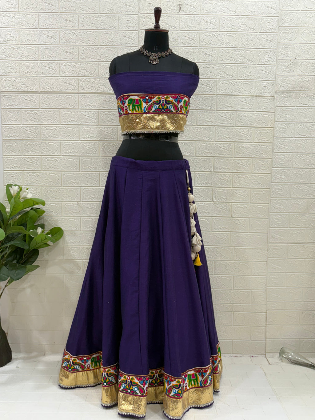 Name:
Purple Navratri Ghaghra Choli Crafted in soft cotton with a vibrant embroidered choli and colorful bandhani dupatta, this ghaghra is perfect for Garba nights and festive celebrations.