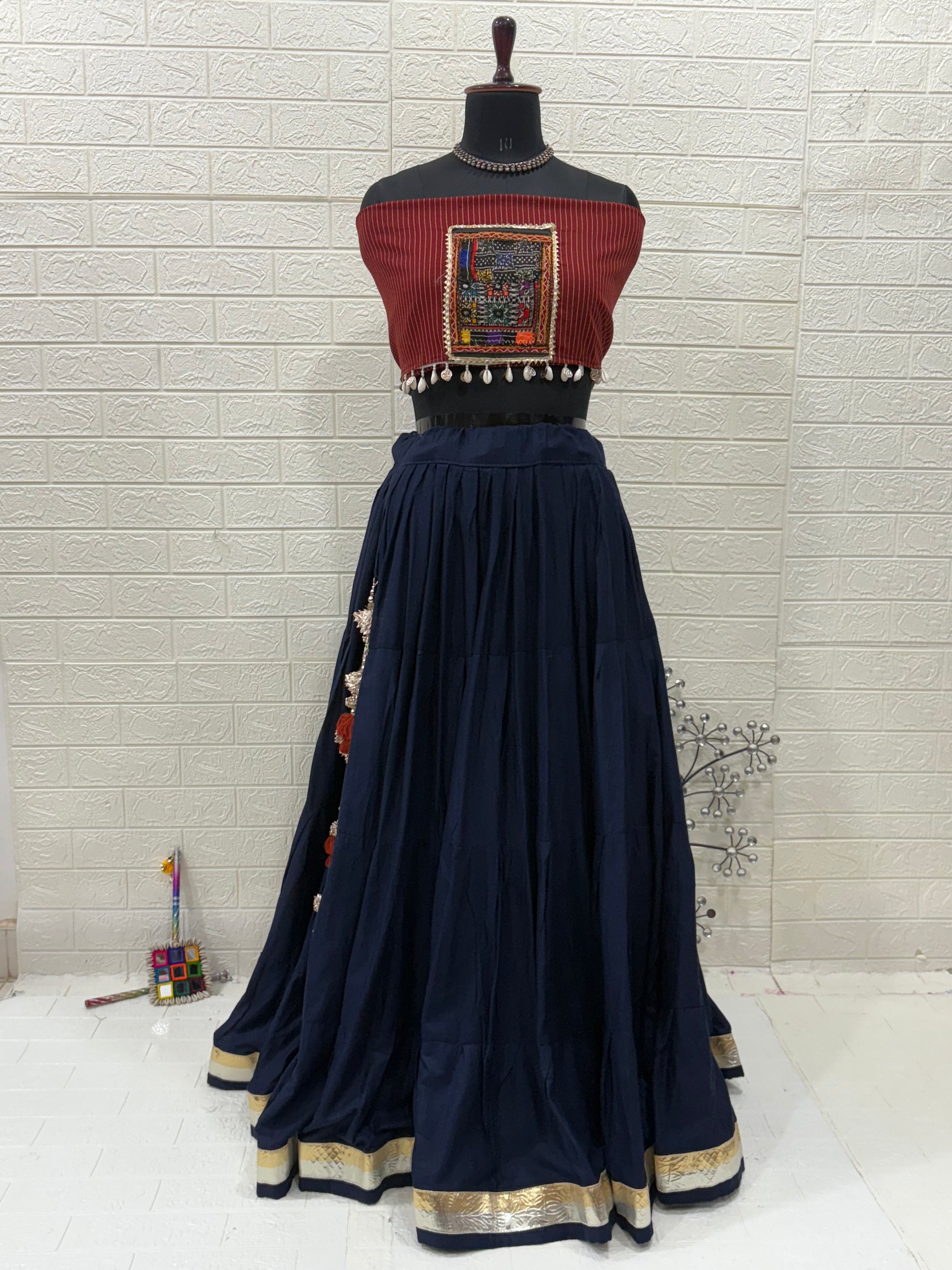 Name: Navy Blue Elegance Lehenga Made With soft cotton flair in deep navy, paired  with a maroon Ajrakh printed and patch blouse for a perfect ethnic fusion look