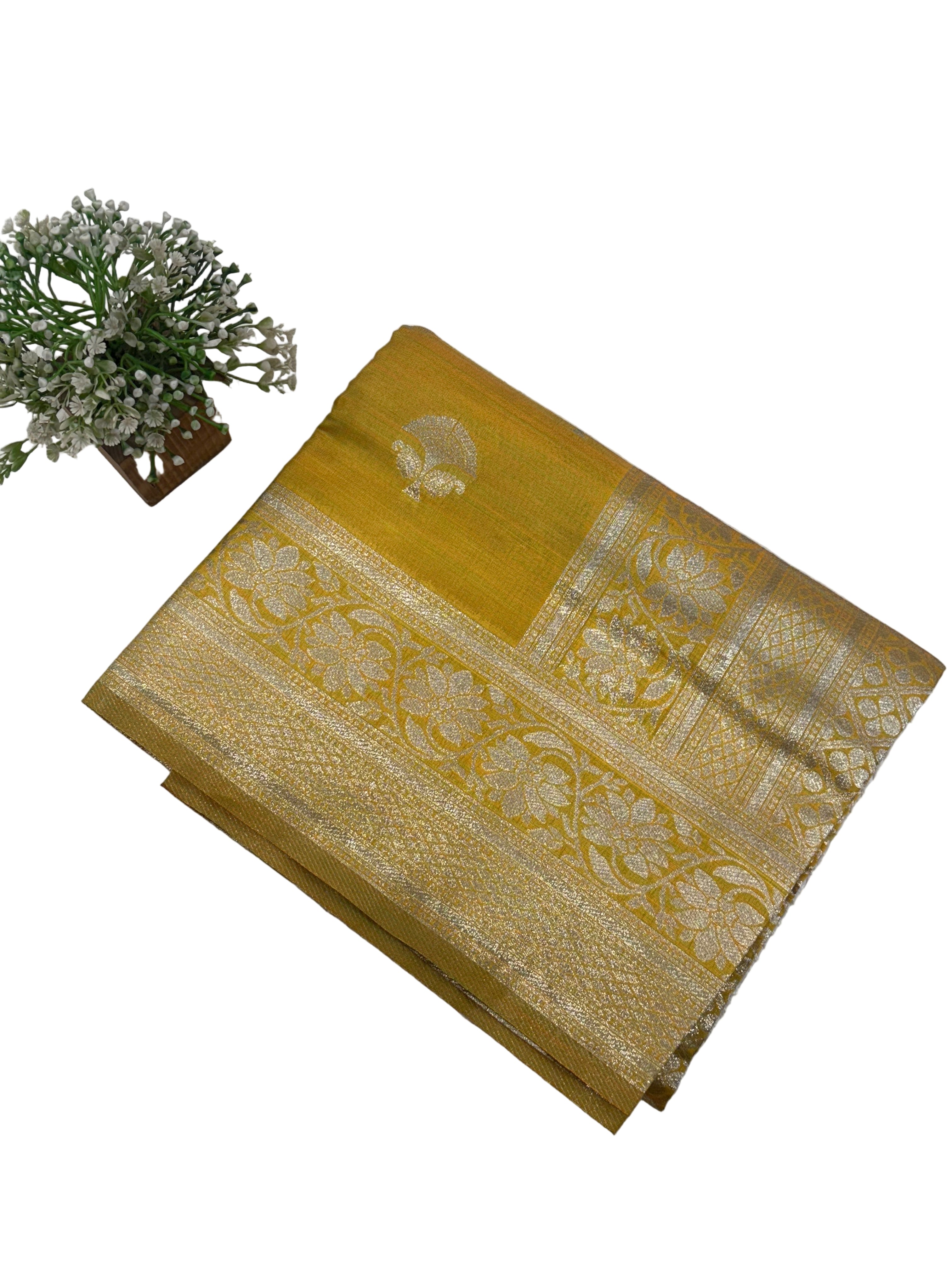 The saree appears to be a Banarasi brocade silk saree it is made of silk with rich zari (metallic thread) brocade weaving characteristic of the Banarasi style from Varanasi India the body features small fish (meen) motifs