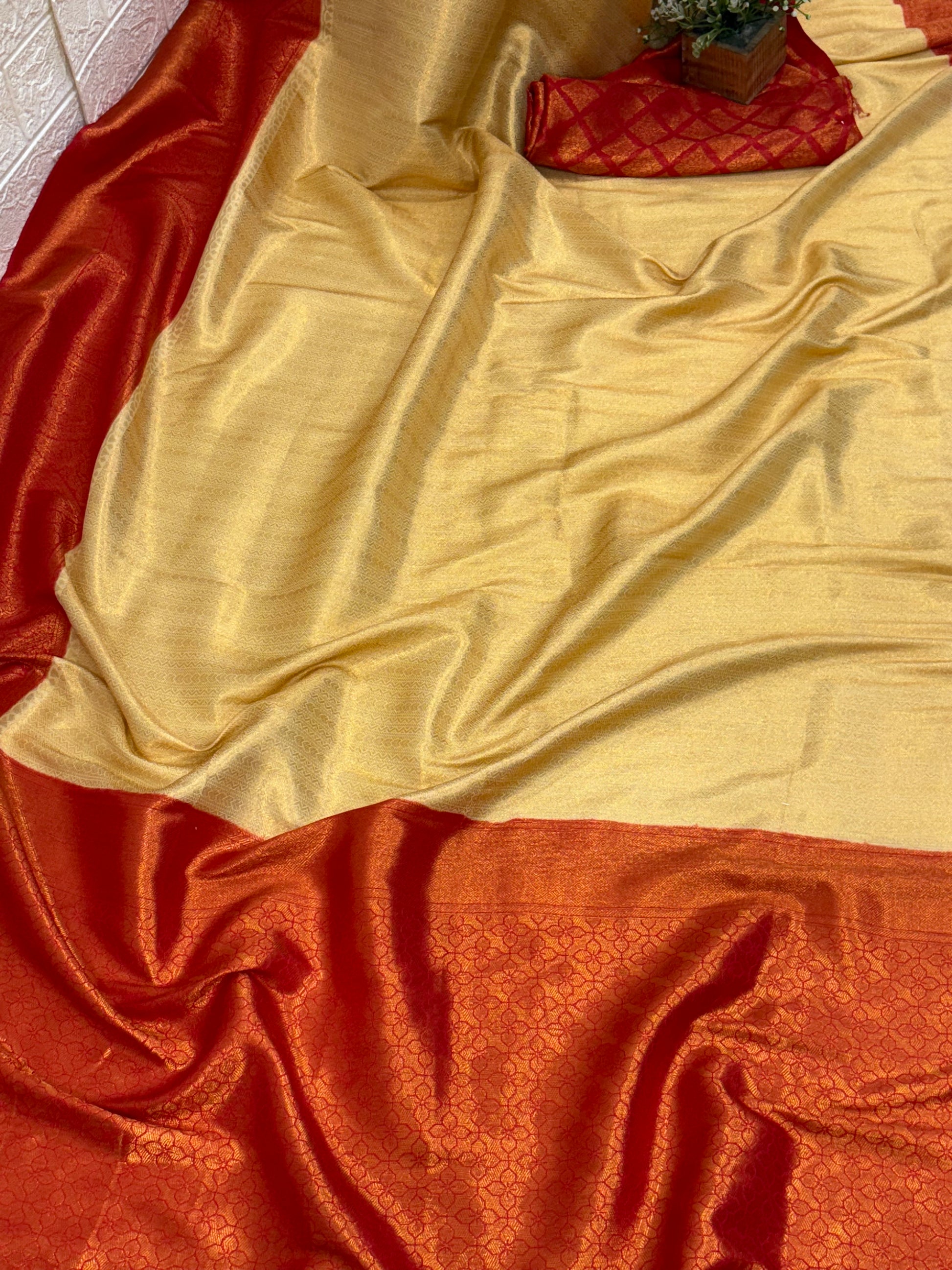 Dual-Tone Rust/Orange Saree kanchipuram silk Fabric A flowing fabric with a lustrous dual-tone (shot) effect, appearing to shift between rust/orange and gold, featuring subtle woven floral buttas/brocade work.