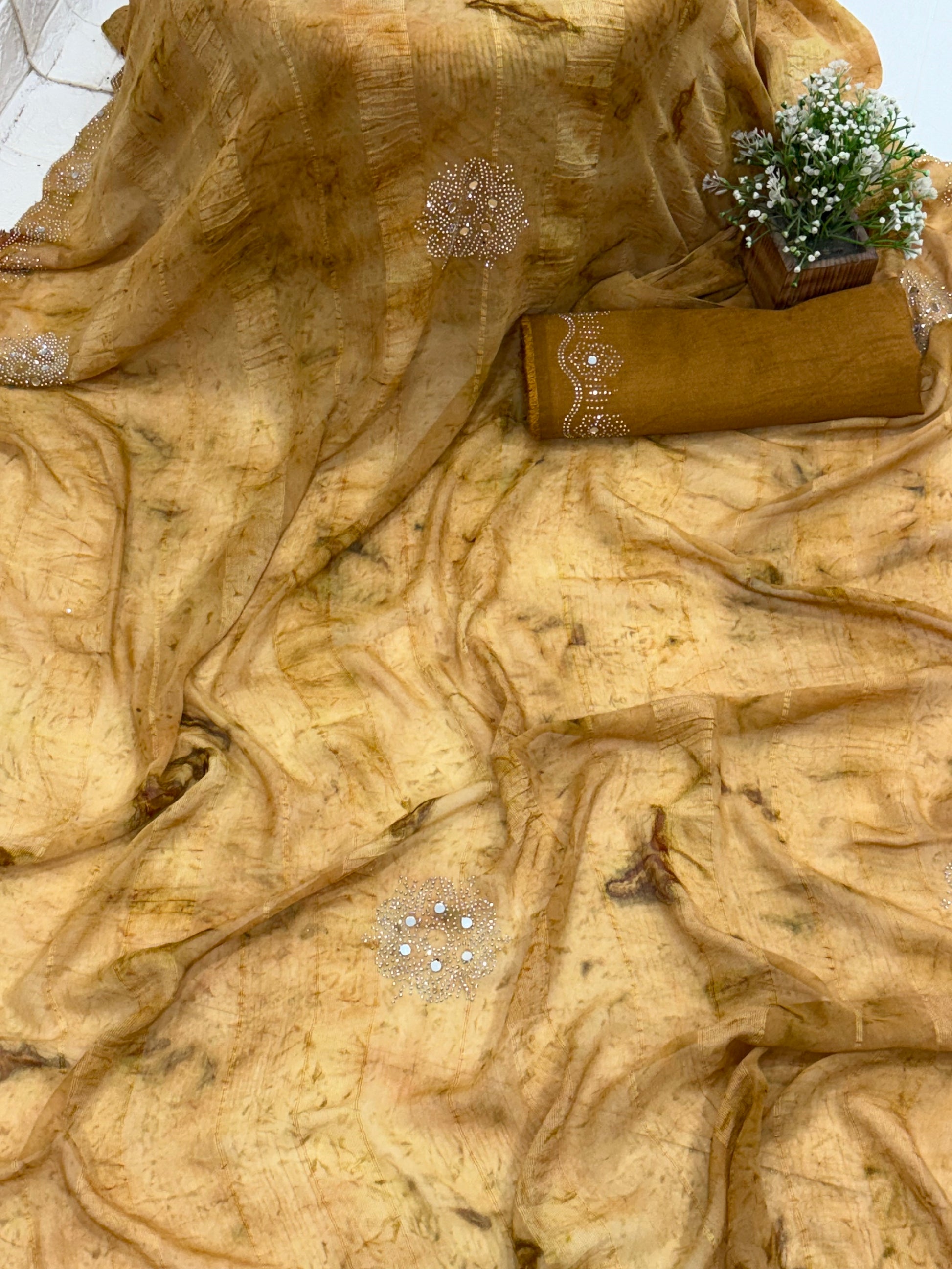 Saree with woven mirror work or light mustard and light brown colour small motif the pattern is a motif woven the sheer georgette fabric silk with mirror work in saree this fabric is known for it’s sheer lightweight texture