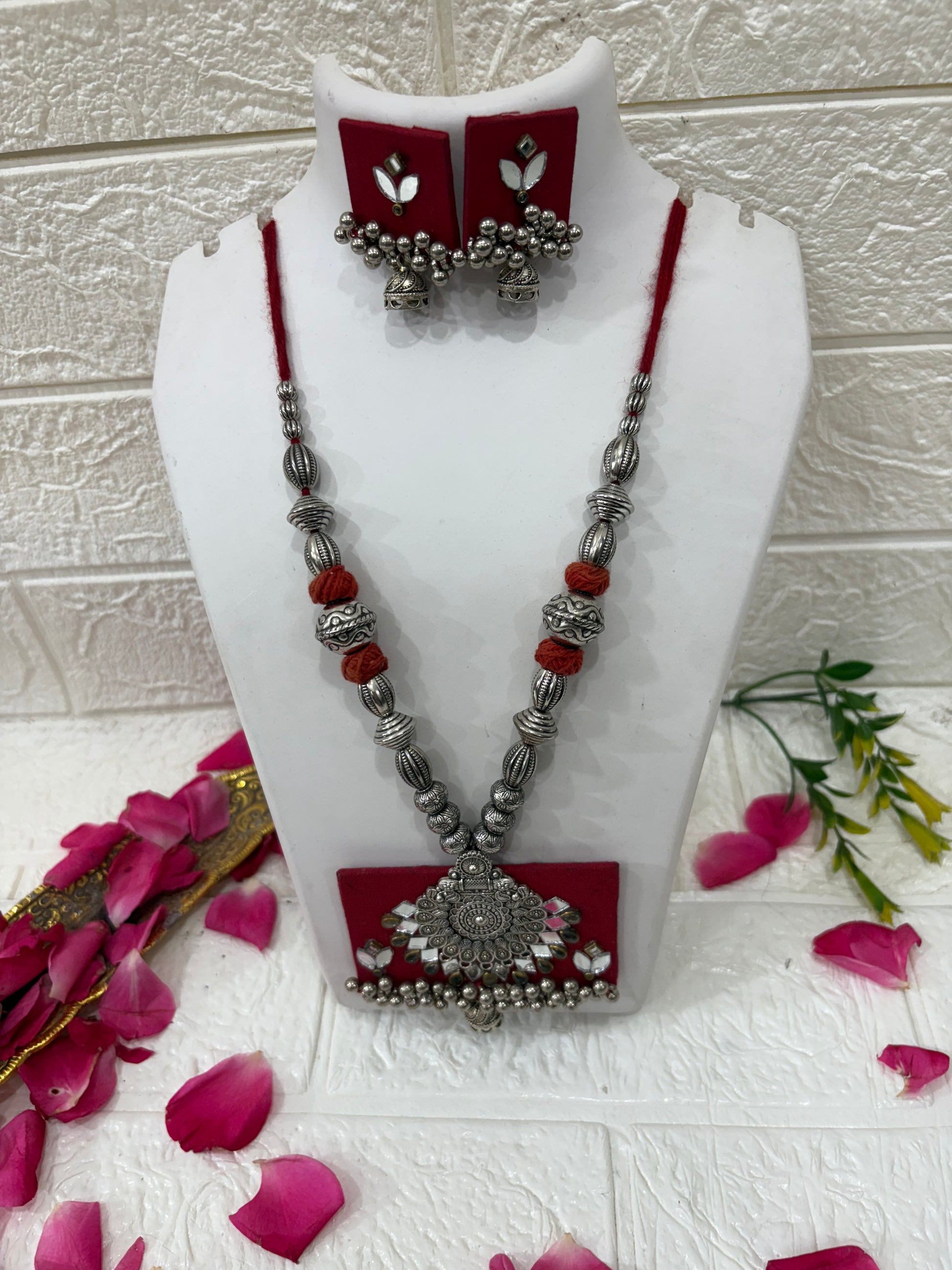 Name:
Red Fabric Pendant Necklace Set with Oxidized Silver Beads & Mirror Work

Collection:
Boho Oxidized Jewelry Collection
(or if you want a festive vibe: Navratri Special Fabric Jewelry Collection)