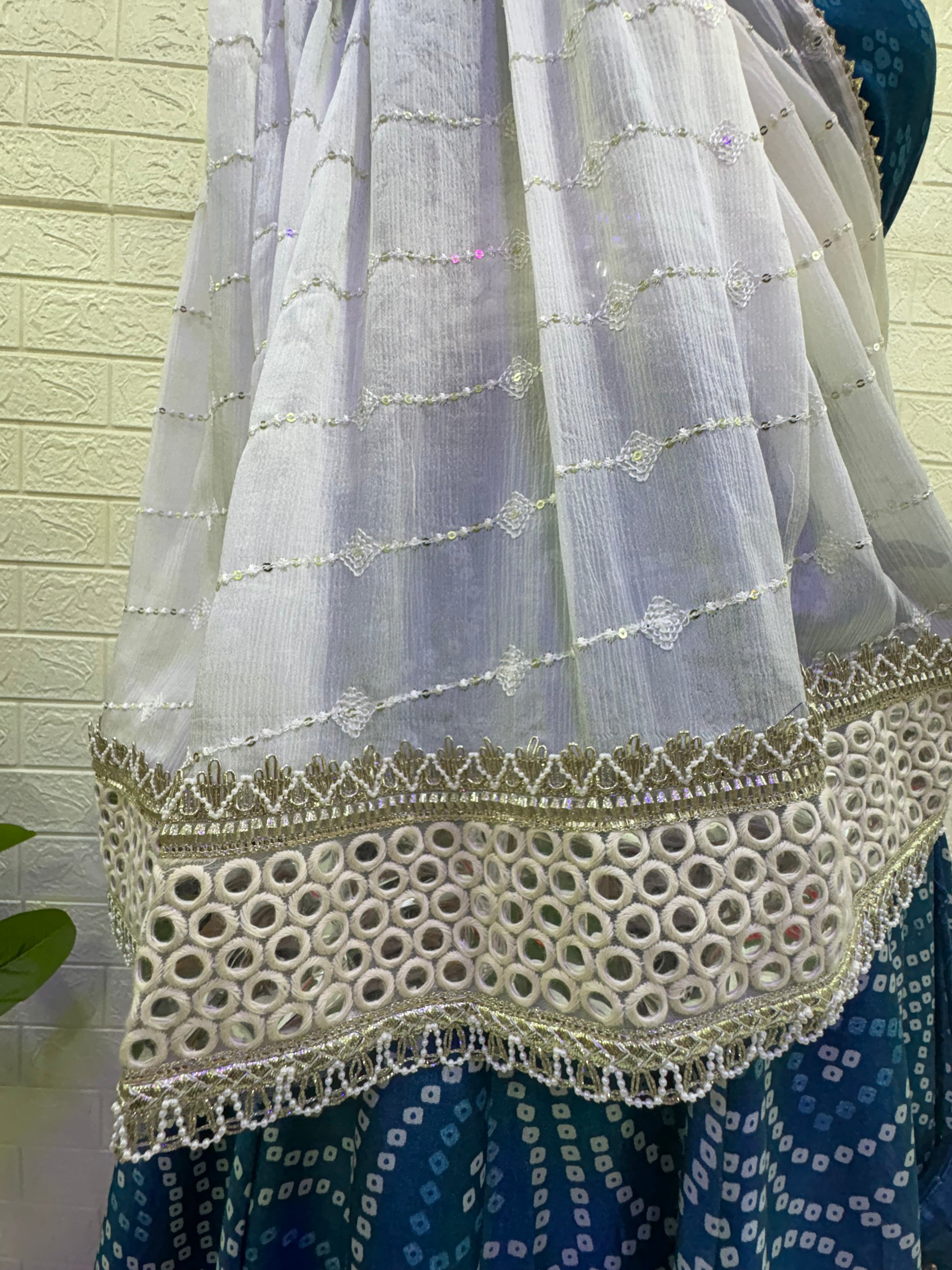 Name:  Blue Bandhani  Lehenga Set Made from soft cotton  Bandhani  print fabric with a mirror work border and paired with a chiffon white dupatta – perfect for festive and traditional celebrations.