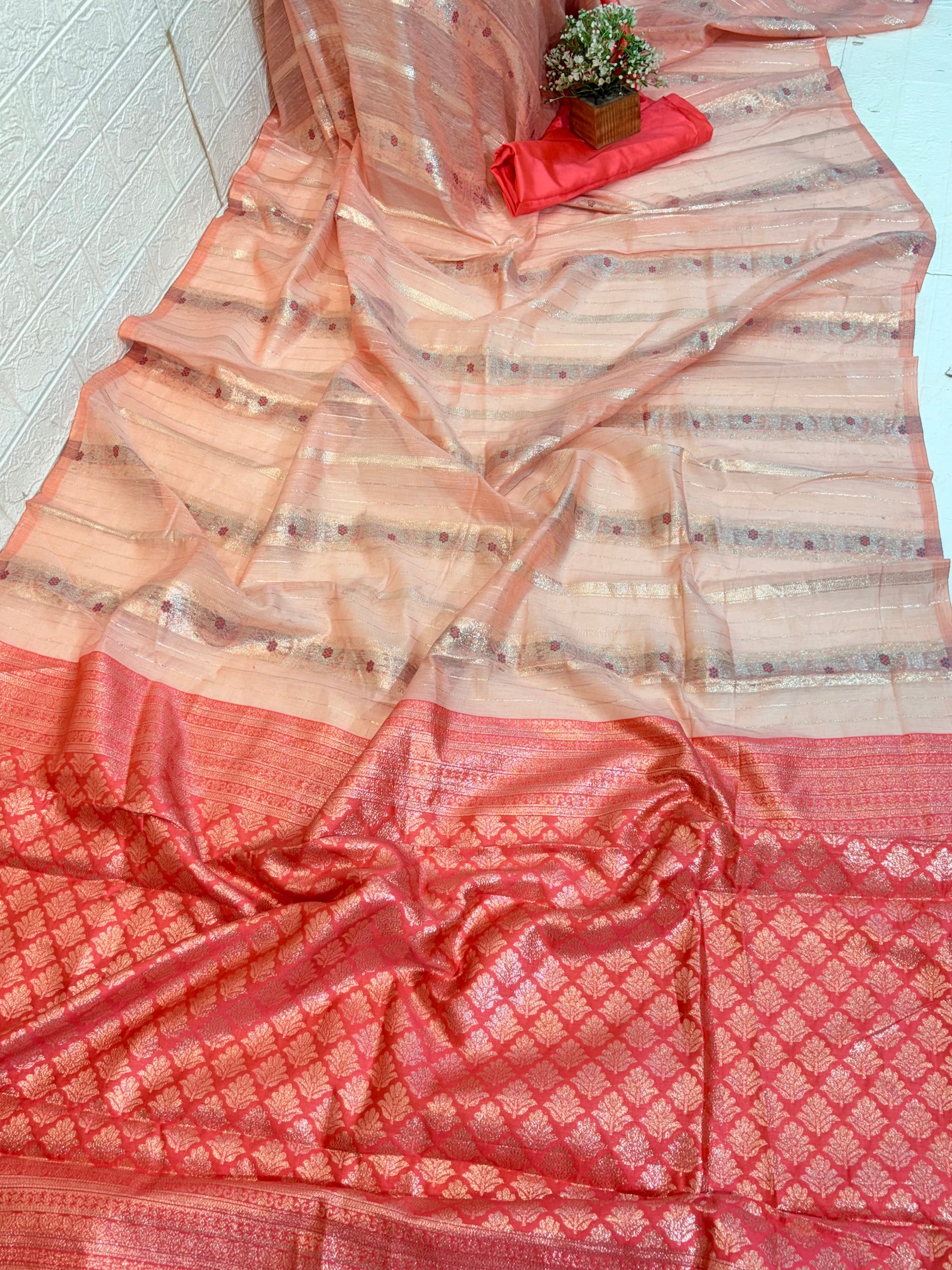 Peach Zari Grace Soft cotton saree with shimmering zari stripes, tiny floral motifs, and a rich coral-toned woven zari border for an elegant festive look.