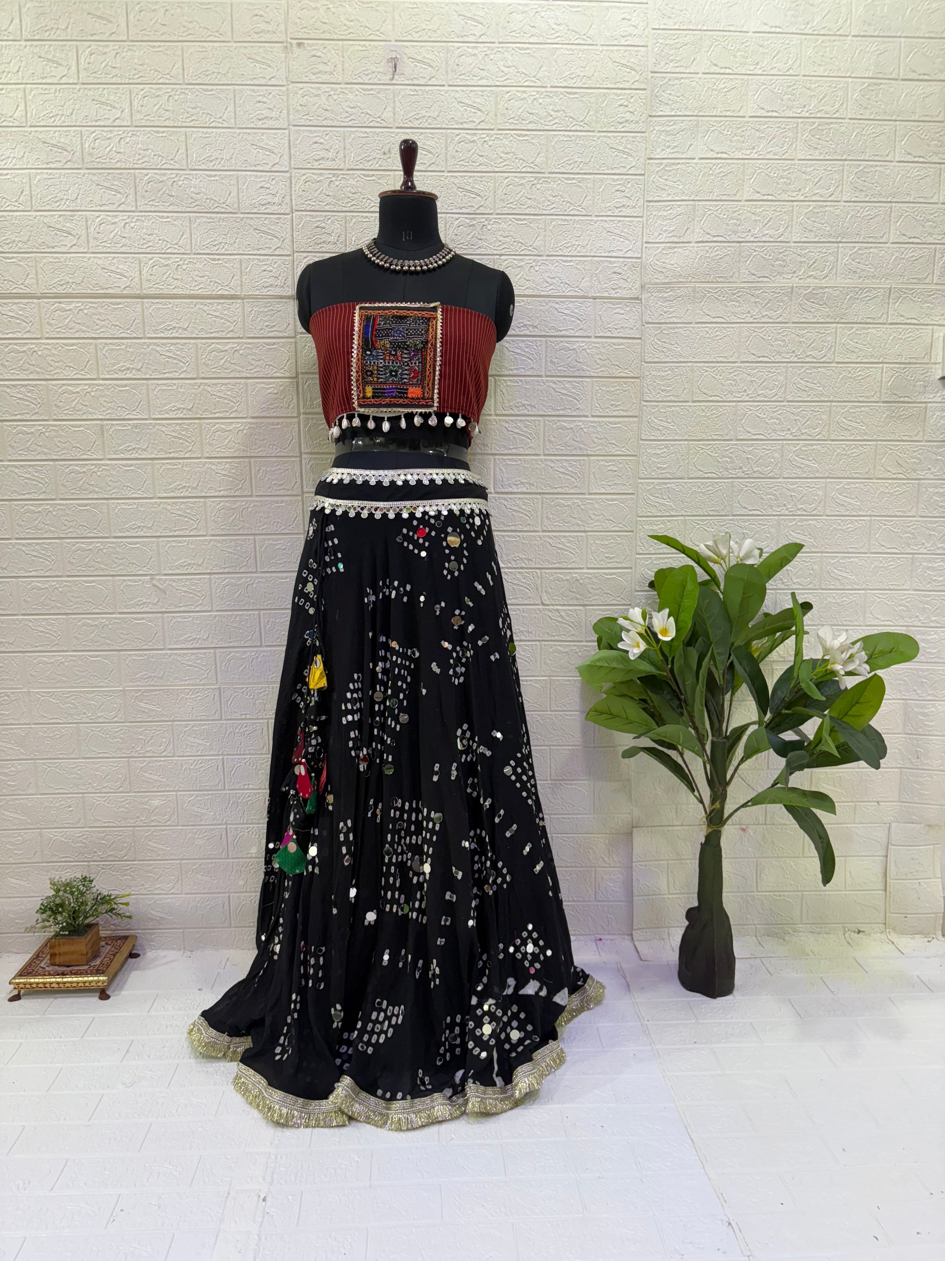 Name:
Midnight Mirror Bandhani Lehenga Elegant black cotton bandhani lehenga with mirror work and colorful tassels, paired with a tribal-inspired Ajrakh blouse for a bold festive vibe.