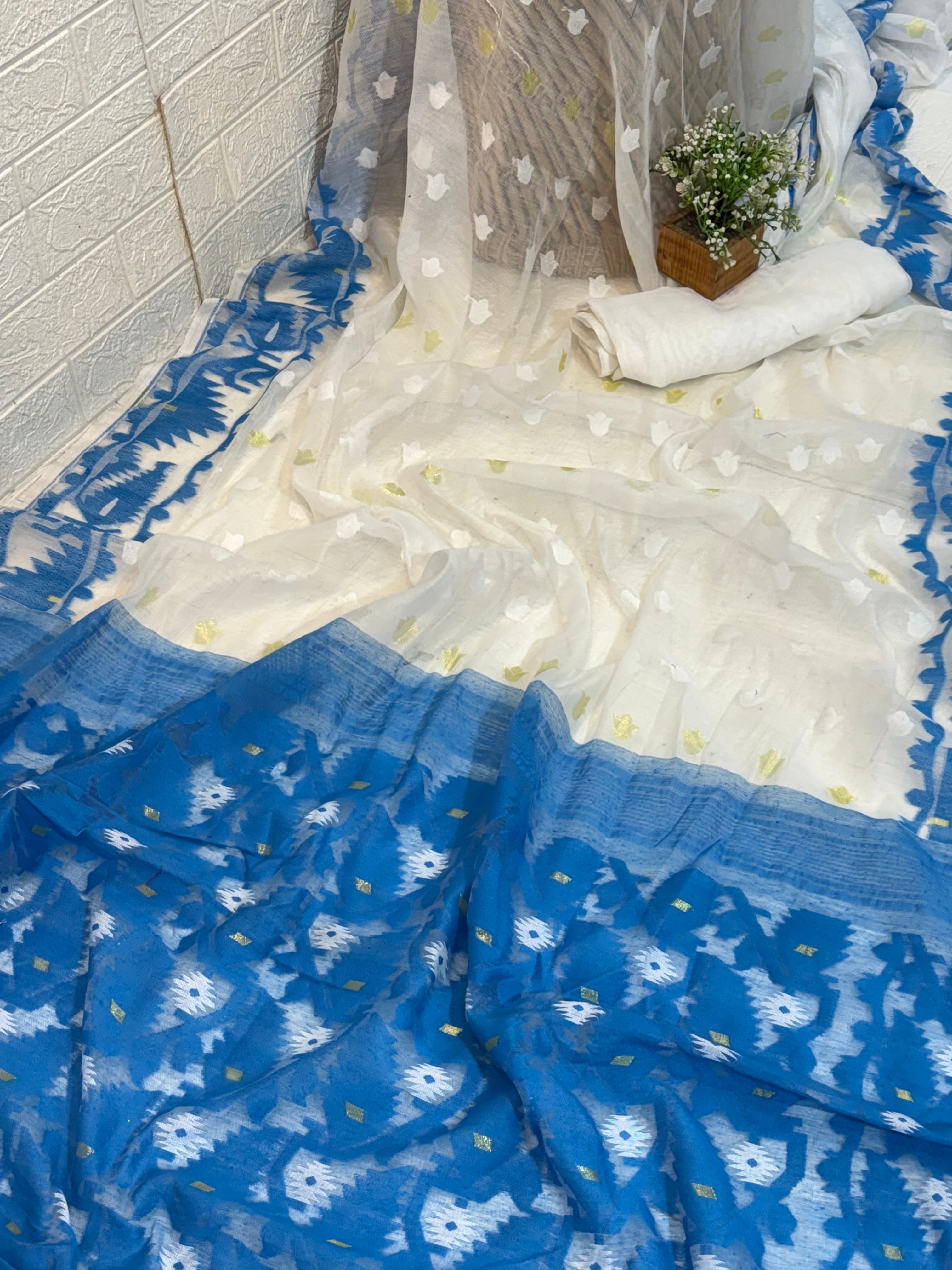 Neel Pushp Jamdani Saree
Crafted in soft cotton Jamdani, featuring a serene white body with delicate buti work and a rich blue woven border for an elegant, airy look.