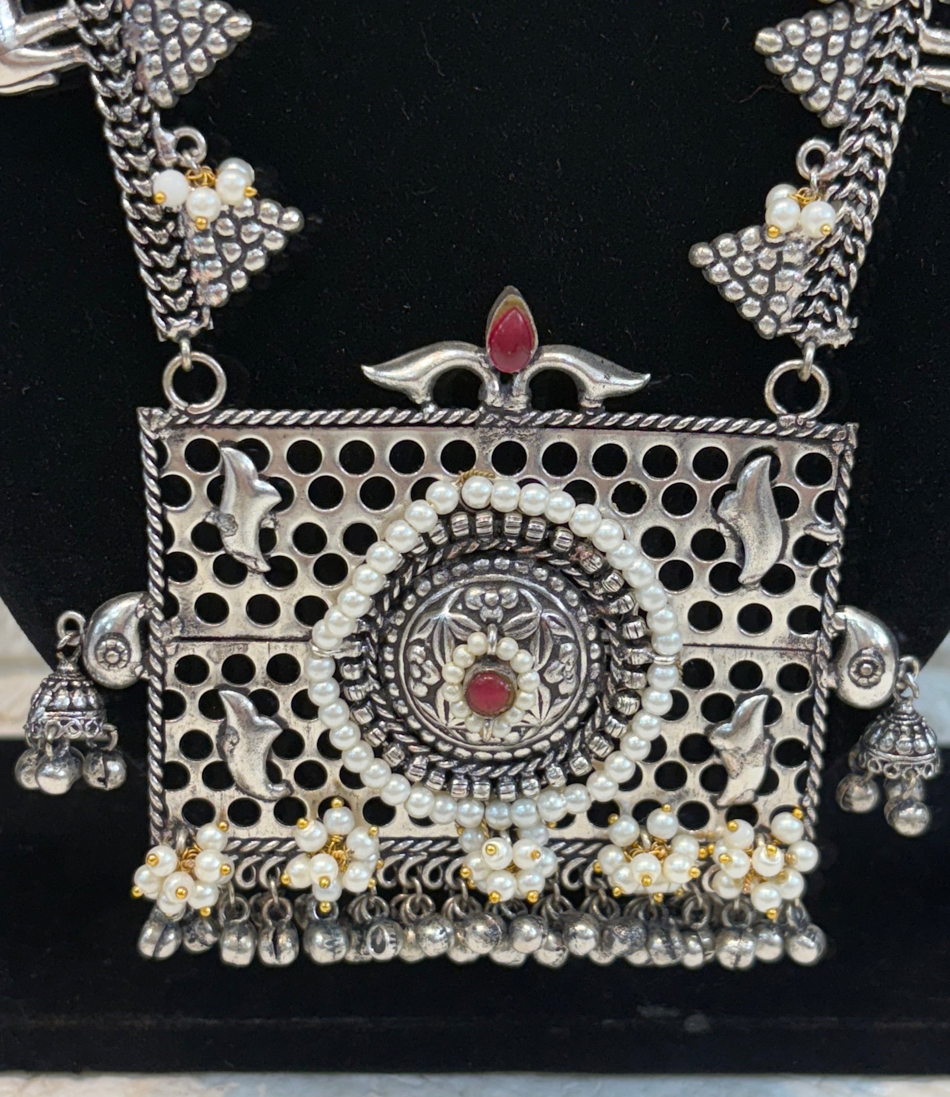 Name: Temple Design Oxidized Silver Necklace Set German silver with intricate elephant motifs, red stone highlights, and pearl bead detailing