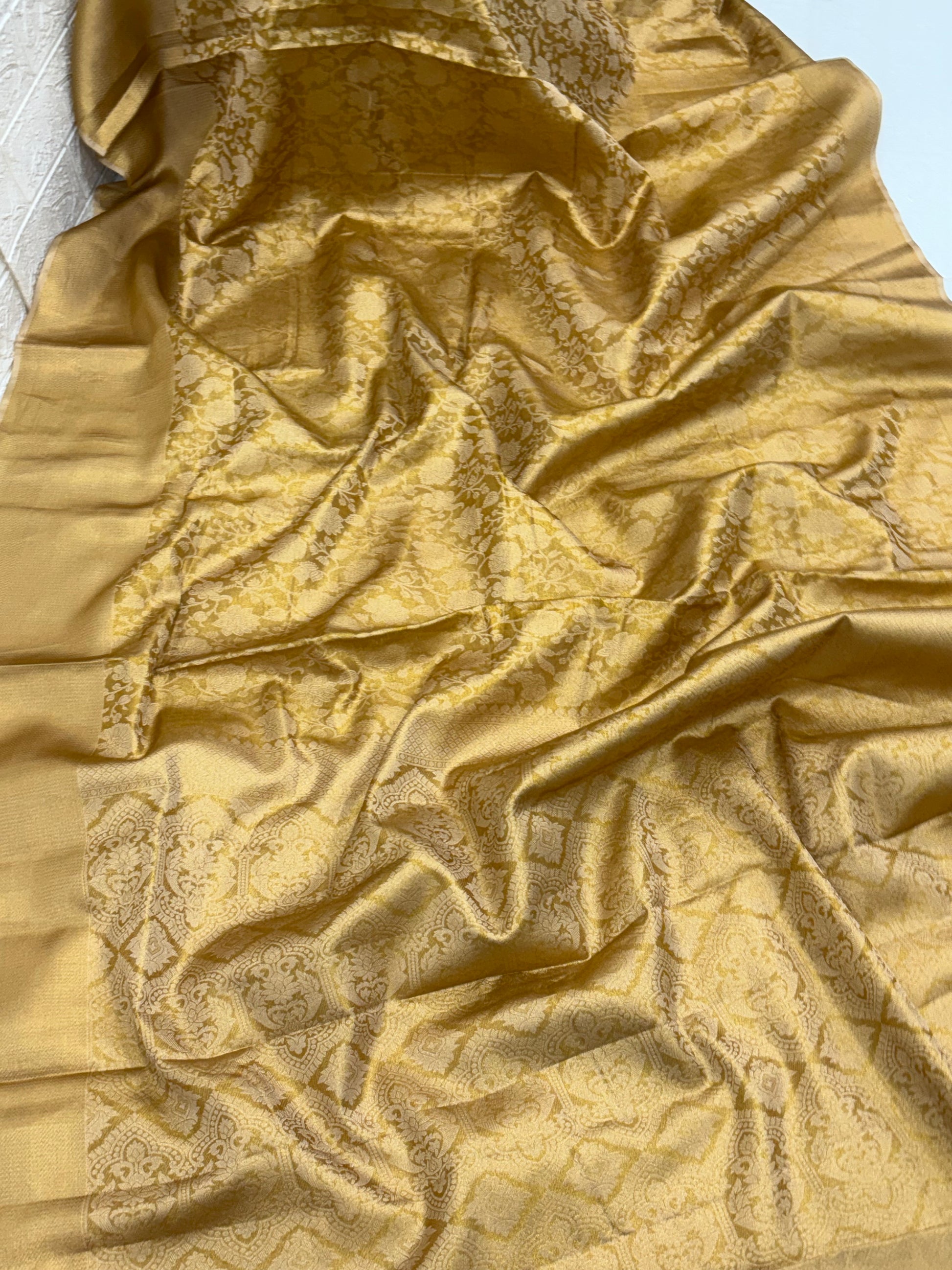 Patola or Kanjivaram Silk Saree / Brocade. And golden colour with Matching blouse This is a silk fabric with all-over woven checkered patterns and floral motifs, often called a checked Kanjivaram or Patola design.