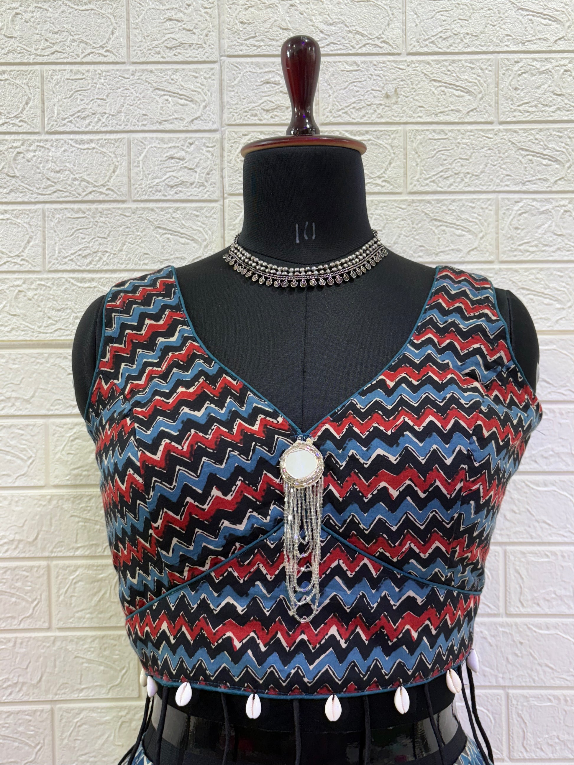 Name: Multi-Color Chevron Lehenga Set Made from lightweight pure cotton blend with chevron print panels, mirror accents, and a stitch sleeveless blouse with  cowrie shell in blouse – perfect for Navratri and festive garba nights.