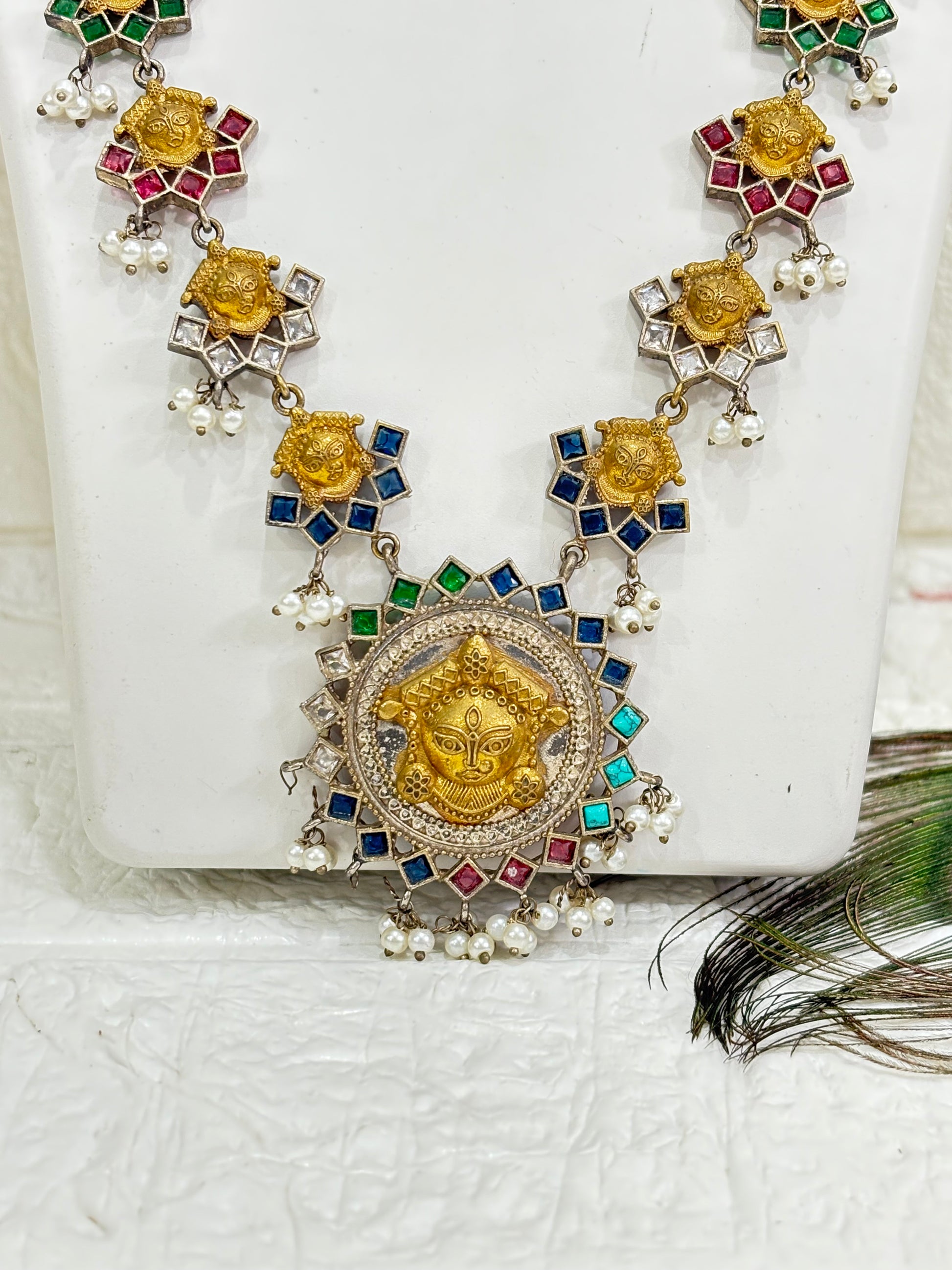 Name: Navrang Devi Haar
Collection: Shaktiya Collection – A divine temple-inspired jewellery line featuring goddess motifs, multicolour stones, and delicate pearl drops, perfect for festive and traditional occasions.