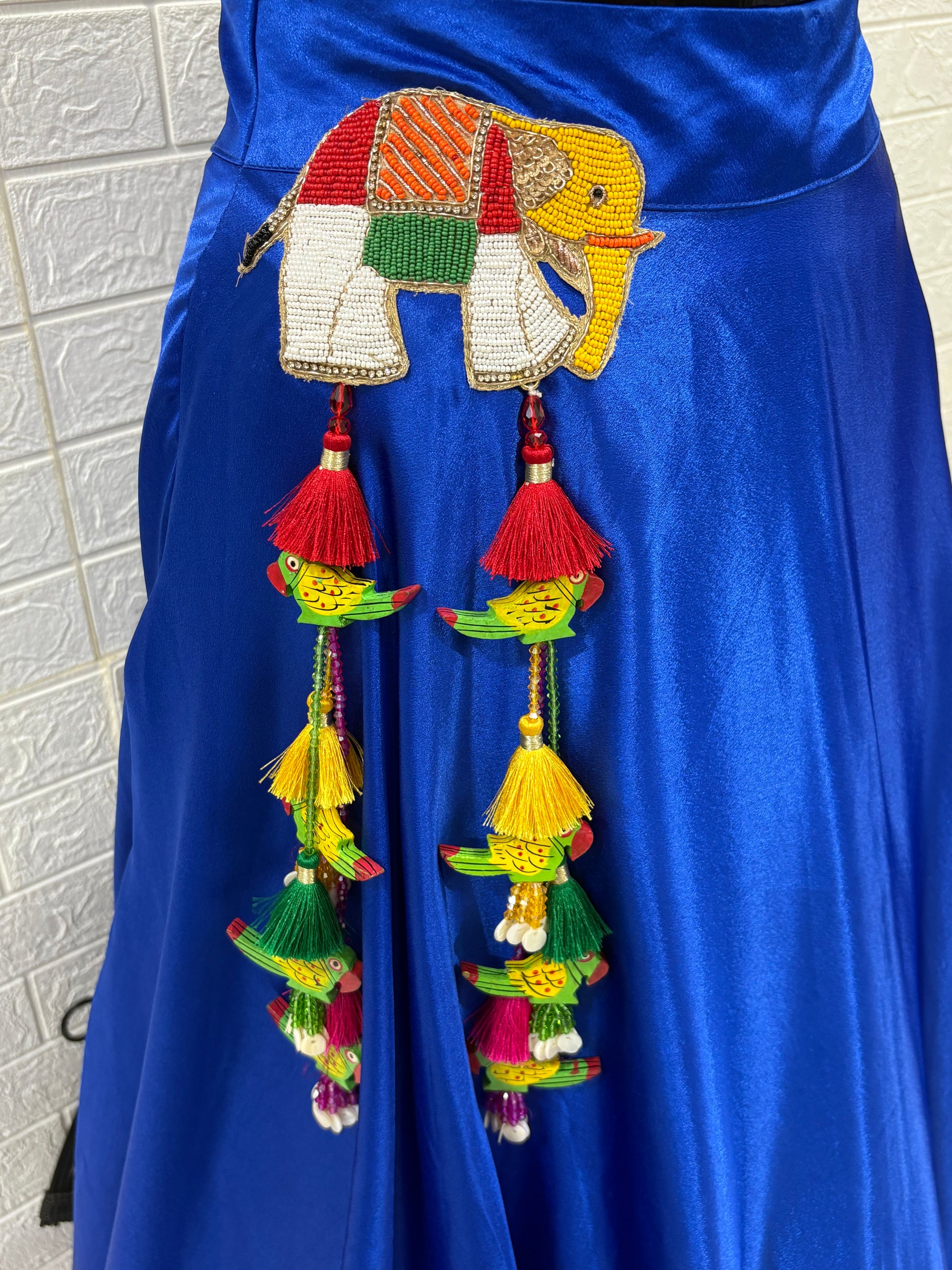 Name: Royal Blue Lehenga & Dupatta A vibrant royal blue crafted in soft pure synthetic satin Lehenga with patchwork,brocade blouse with mirror work Bandhni Dupatta and sequin lace, perfect for festive celebrations.