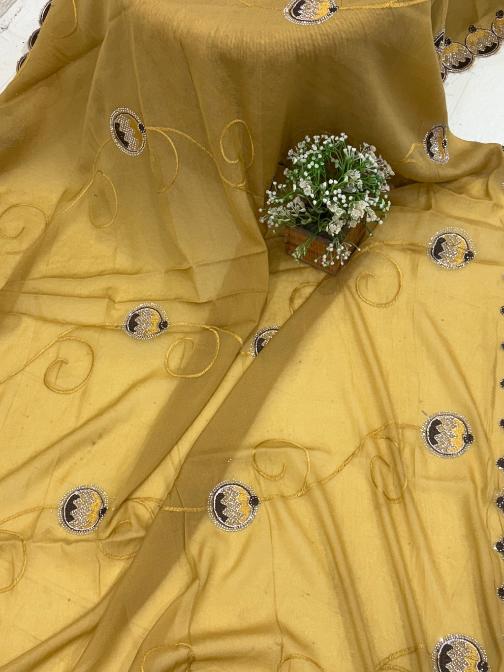 Saree georgette or organza and mustard colour Embroidered Medallion butti and Saree with Scalloped Border it is a sheer saree with scattered embroider and stonework