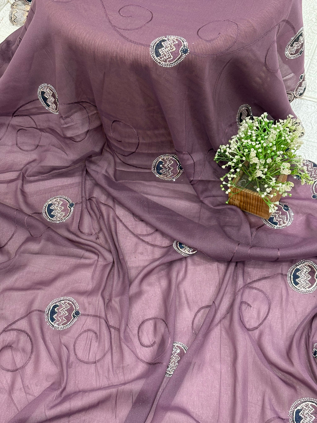 Saree Purple Embroidered Saree with purple mauve and georgette or organza Medallion Butti and Scalloped Border. It is a sheer saree with scattered embroidery and stonework.