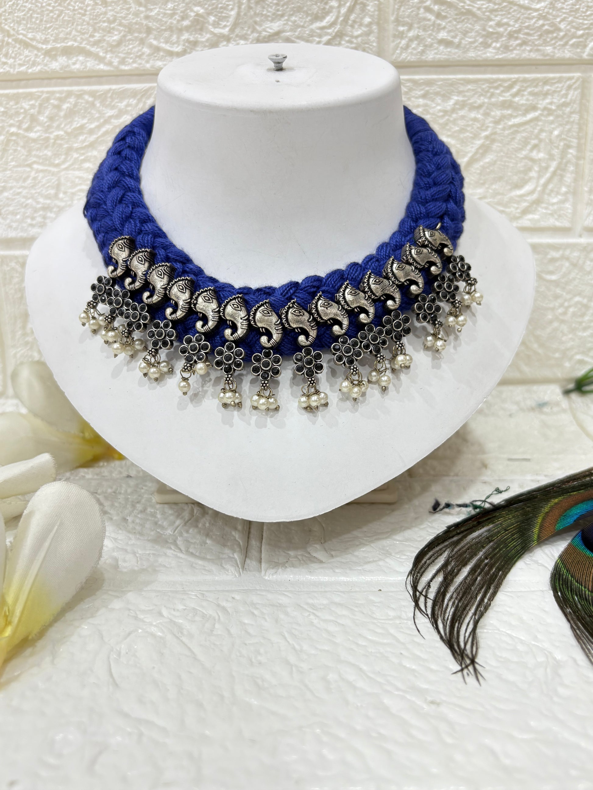 Name: Hathi Ghungroo Choker
Collection: Vanya Collection – A tribal-inspired range featuring oxidised elephant charms, floral motifs, and ghungroo drops on a vibrant blue thread base.
