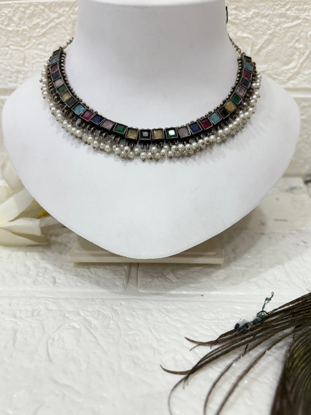 NAME: Boho Mirror Pearl Choker Set Oxidised silver choker adorned with multicolour square stones and pearl drops, paired with matching earrings. Ideal for festive and traditional looks.