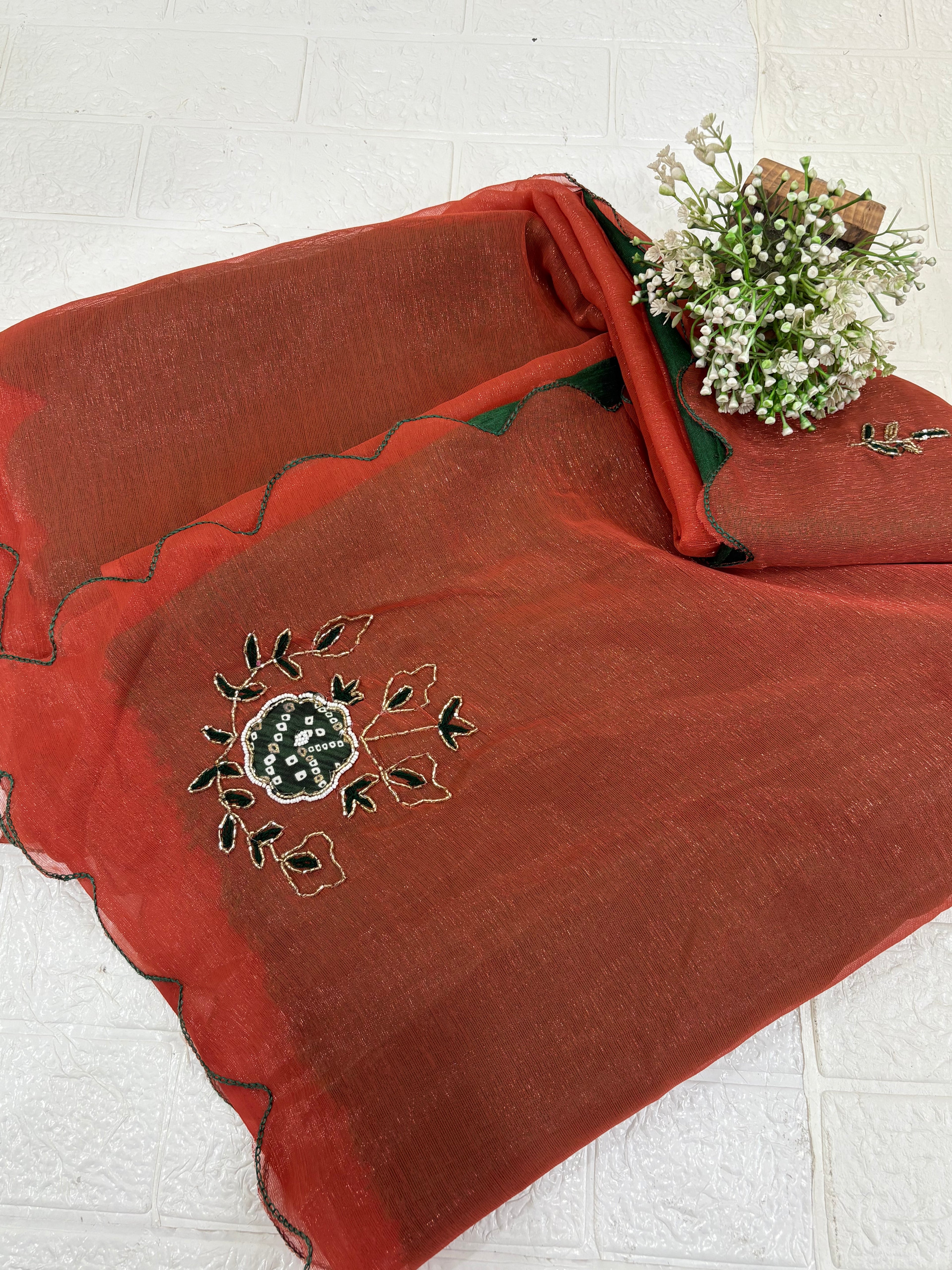 This fabric is a rust peach shimmer with embroiderd  organza with a soft shimmer, featuring delicate thread embroidery in Green and gold. The edges have a fine scallop finish, giving it a graceful drape.