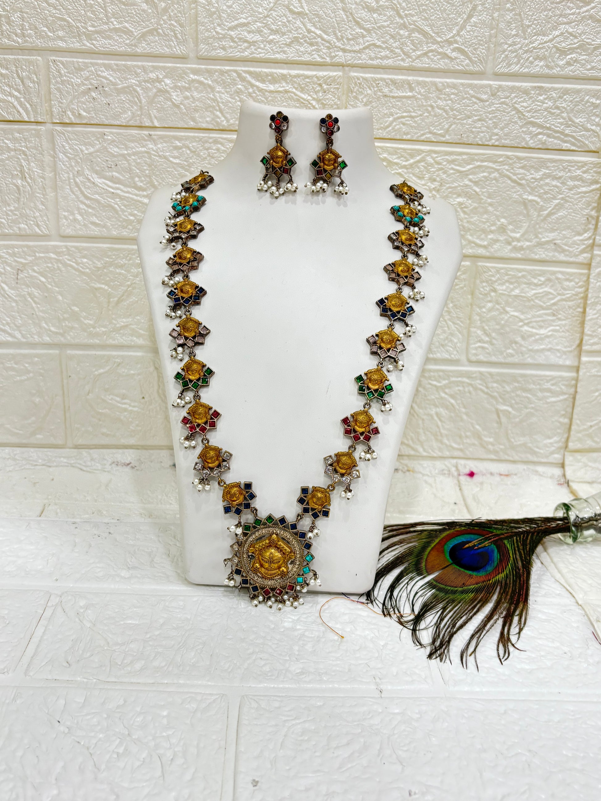Name: Navrang Devi Haar
Collection: Shaktiya Collection – A divine temple-inspired jewellery line featuring goddess motifs, multicolour stones, and delicate pearl drops, perfect for festive and traditional occasions.