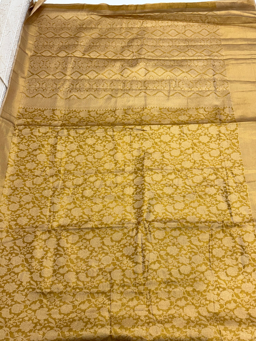 Patola or Kanjivaram Silk Saree / Brocade. And golden colour with Matching blouse This is a silk fabric with all-over woven checkered patterns and floral motifs, often called a checked Kanjivaram or Patola design.