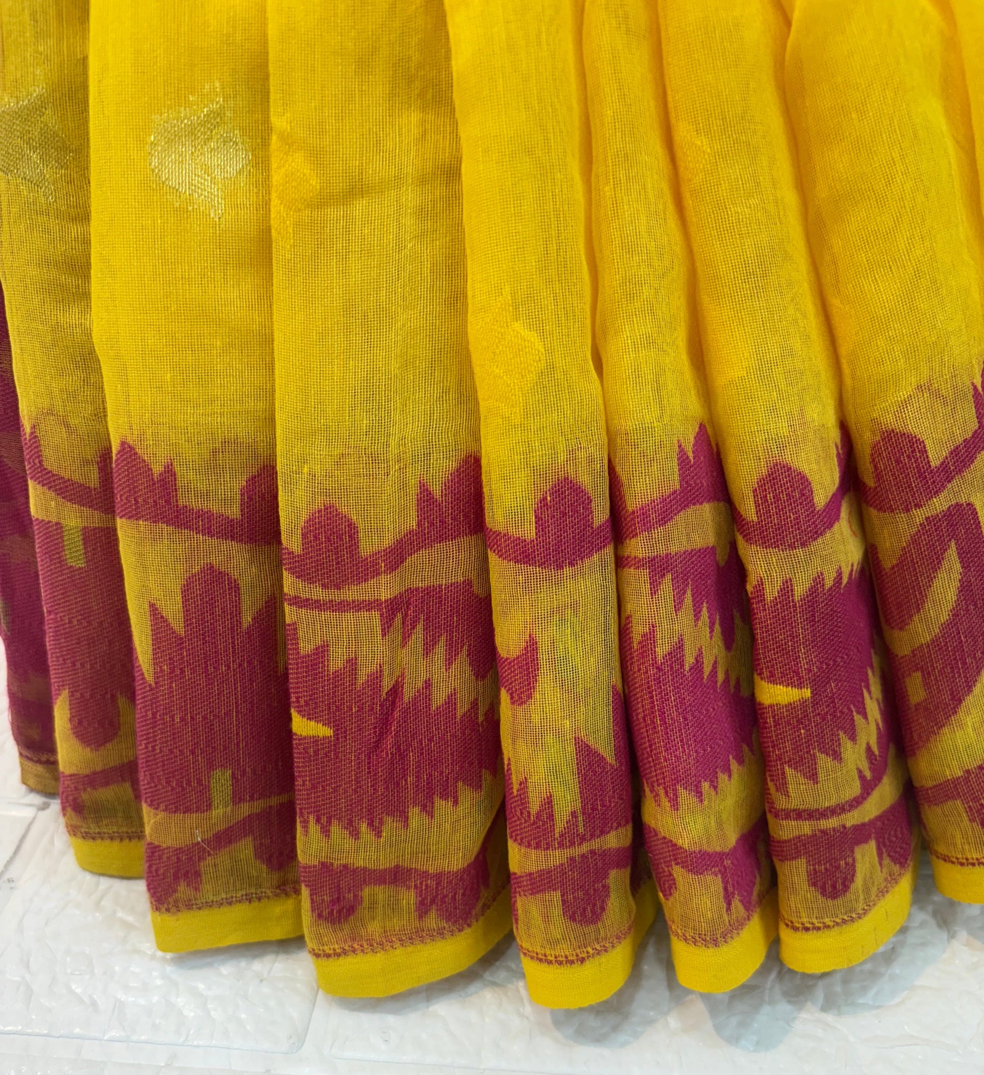 Sunrise Magenta Jamdani Saree cotton Jamdani, featuring a bright yellow body with magenta contrast border and delicate handwoven motifs, light and airy in feel.
