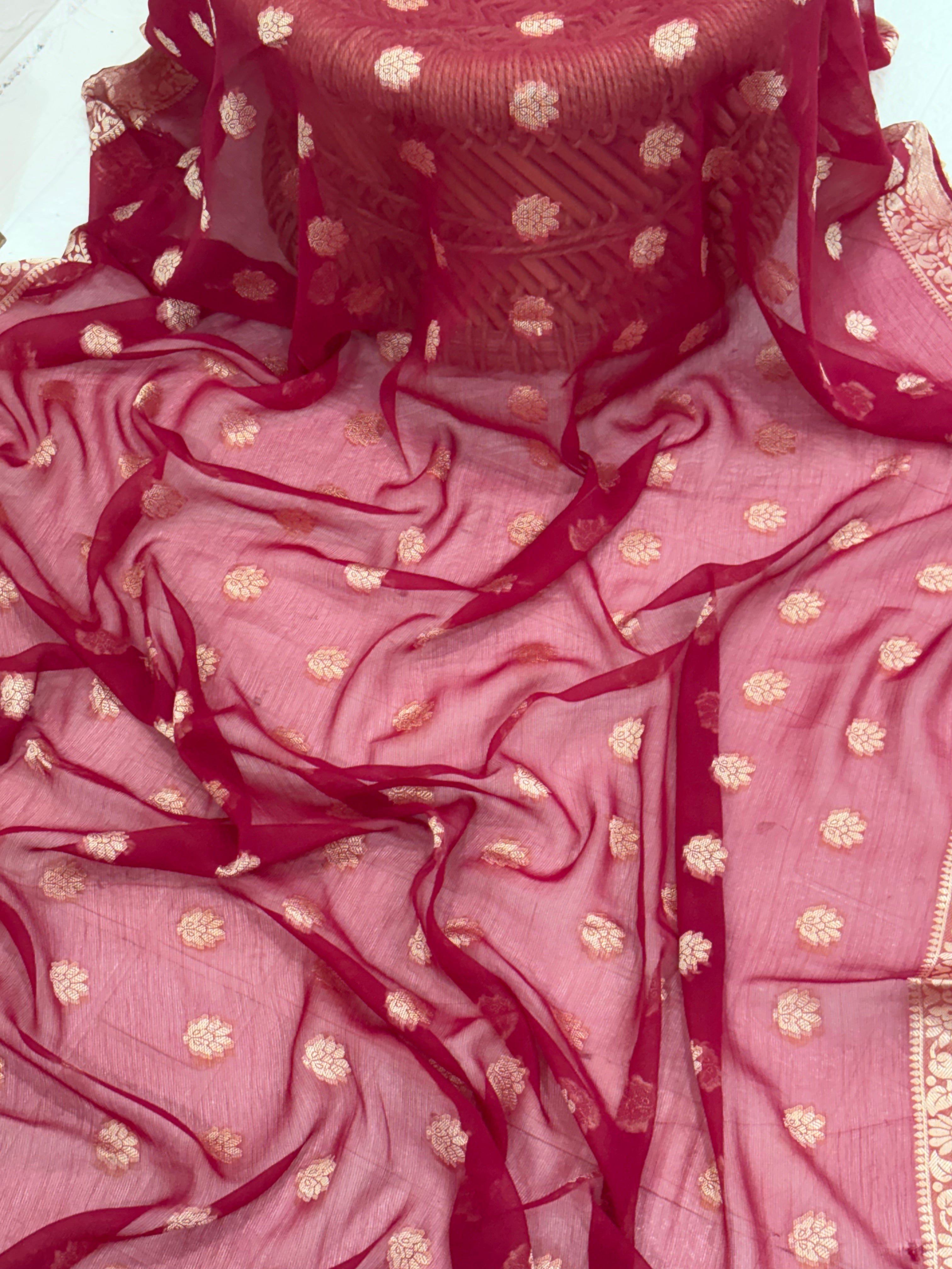 This fabric is a maroon soft Georgette with all over gold zari floral buti embroider and a rich woven border paired with a matching plain blouse perfect for festival