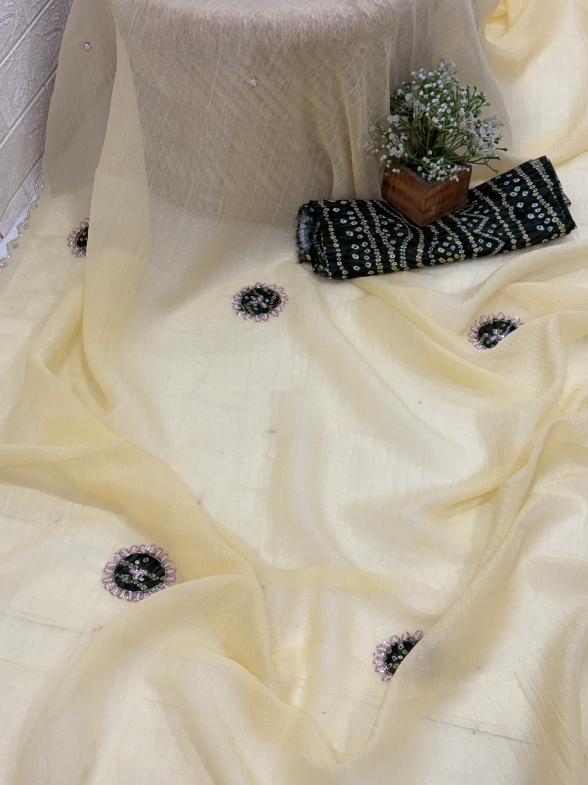 Light yellow crepe Saree with a sheer, lightweight fabric forest green Bandhani print blouse base embellished with sequins and embroidery butas.