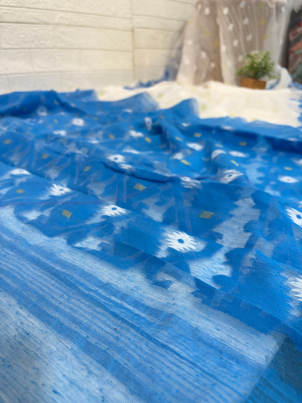 Neel Pushp Jamdani Saree
Crafted in soft cotton Jamdani, featuring a serene white body with delicate buti work and a rich blue woven border for an elegant, airy look.