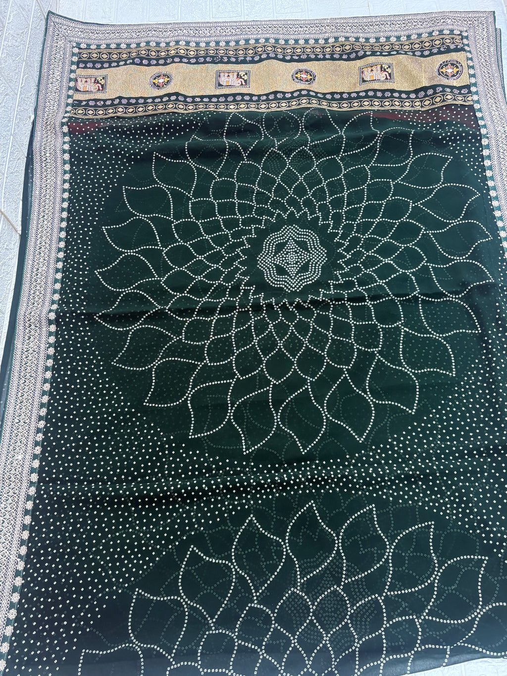 Name: Emerald Bandhej saree Traditional georgette saree featuring intricate bandhej patterns with golden zari and ethnic motif border.