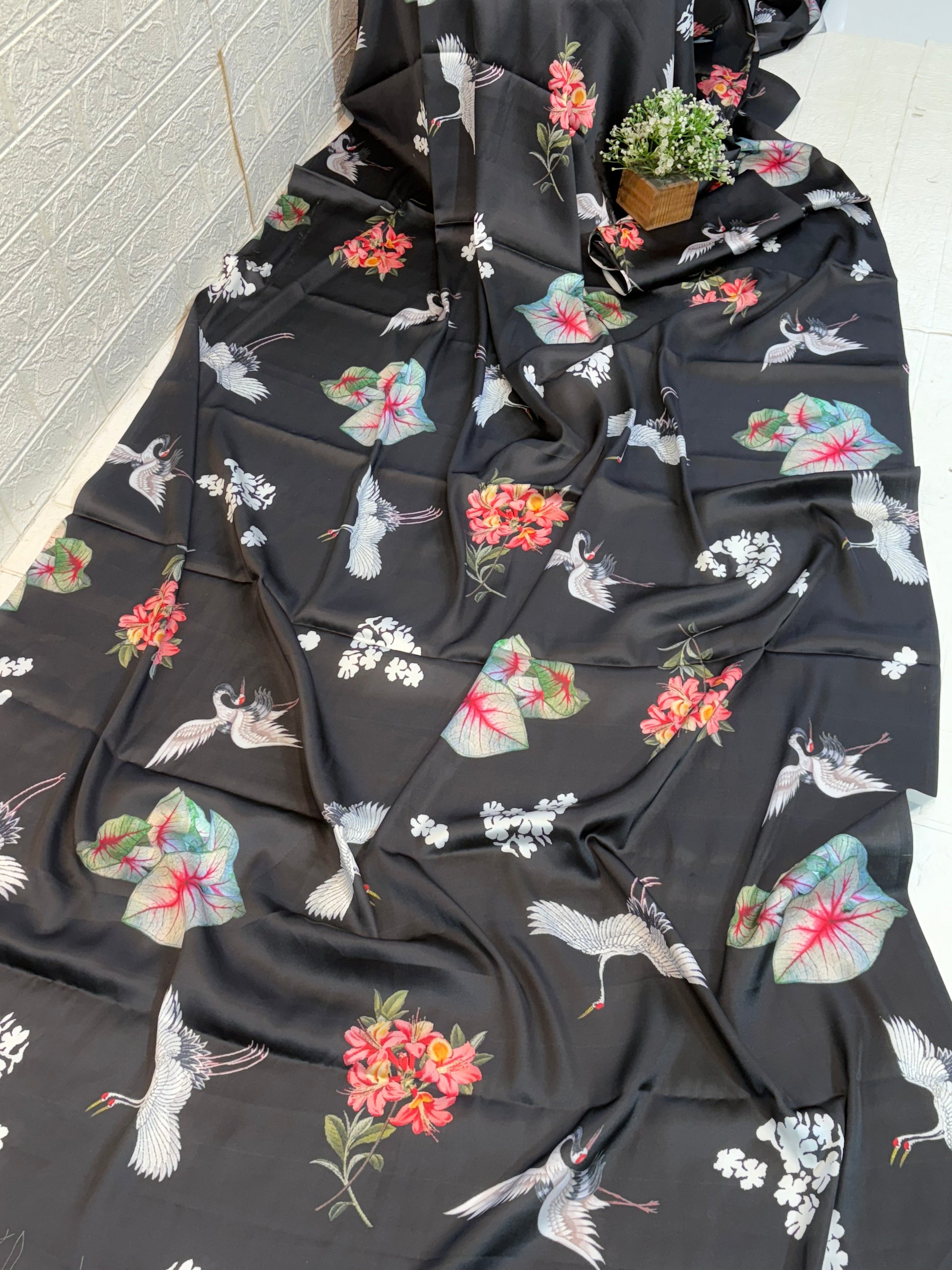 Midnight Crane Floral Saree
Made from soft satin fabric, this black saree is adorned with elegant crane bird and floral prints, offering a smooth drape with a modern, graceful appeal.