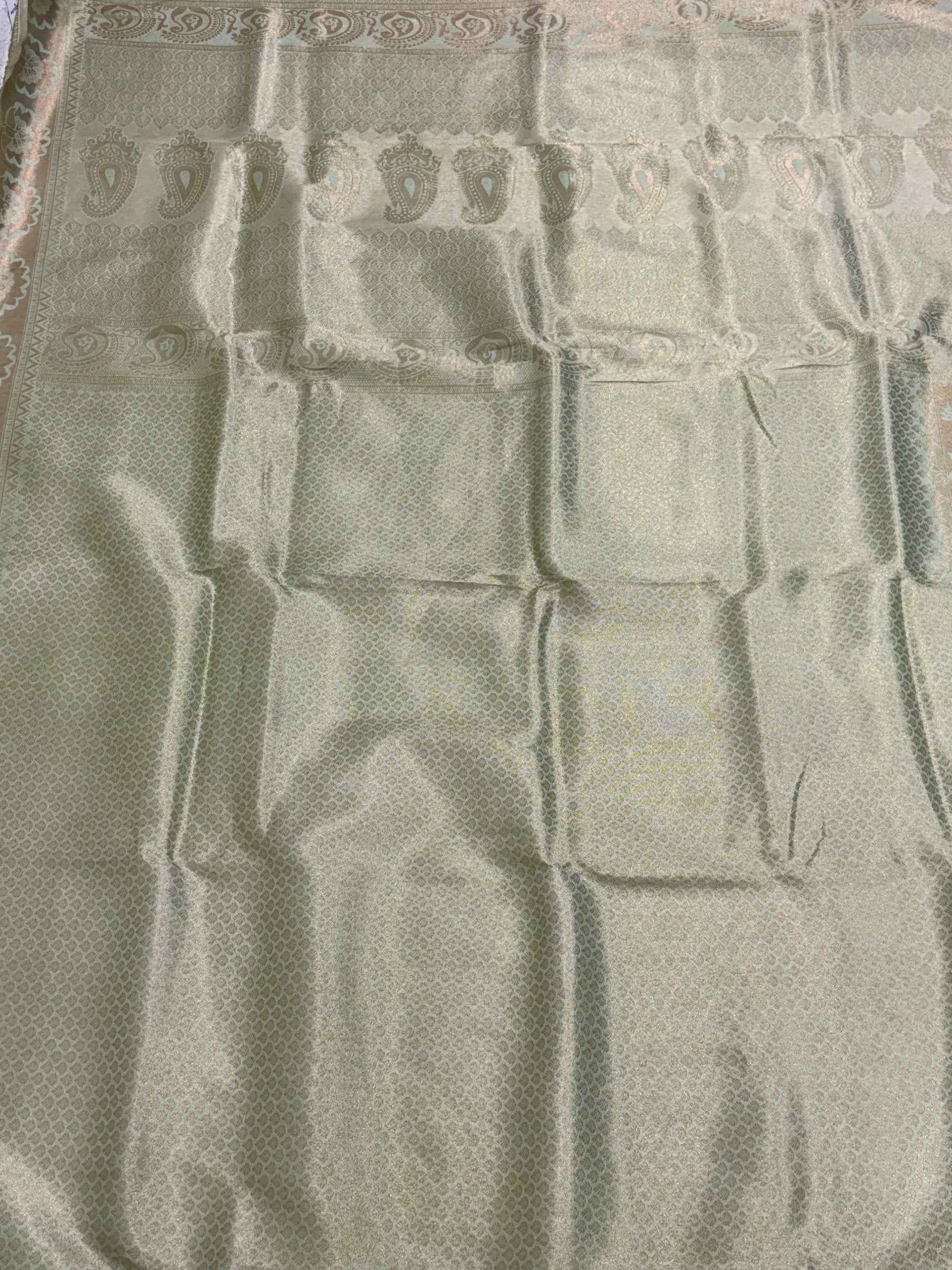 Kanchipuram silk a traditional dual-panel fabric featuring a short-effect. Pista green colour and golden top with woven motifs and a light green  aqua- coloured bottom with woven self-stripes