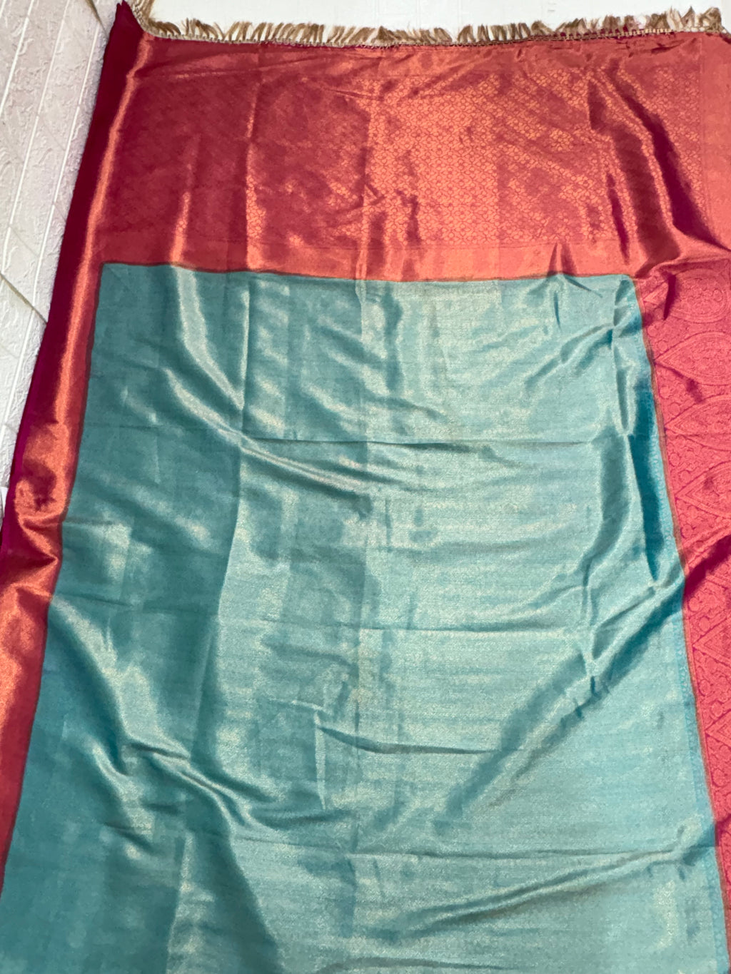 Kanchipuram Silk  (Silk Blend) A traditional dual-panel fabric, featuring a shot-effect reddish-pink and  golden top with woven motifs and a light blue aqua-colored bottom with woven self-stripes.