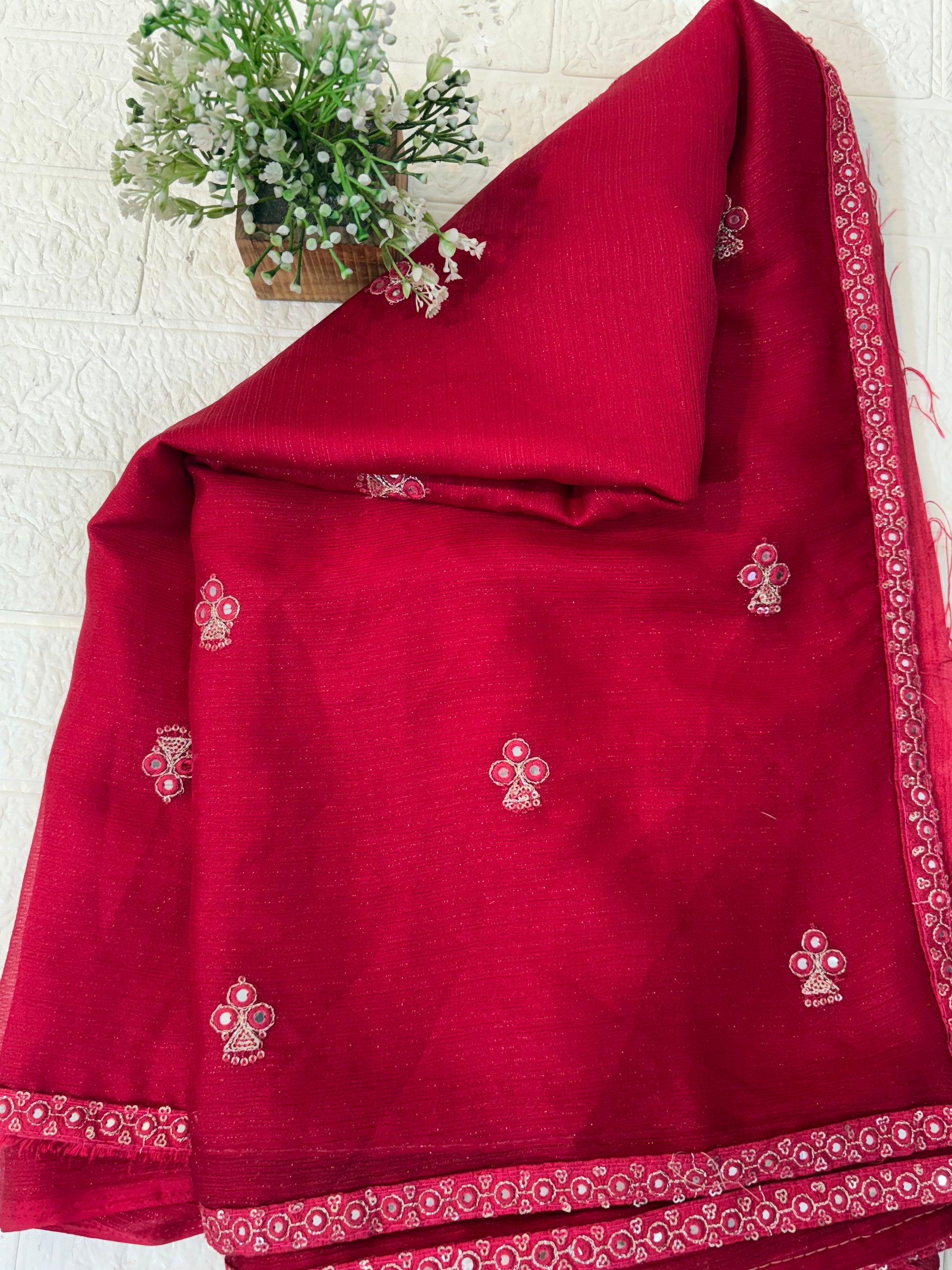 Crimson Pearl Butti Saree
Made from soft georgette fabric, this elegant red saree is adorned with delicate pearl butti work, giving a light, graceful drape perfect for festive and party wear.
