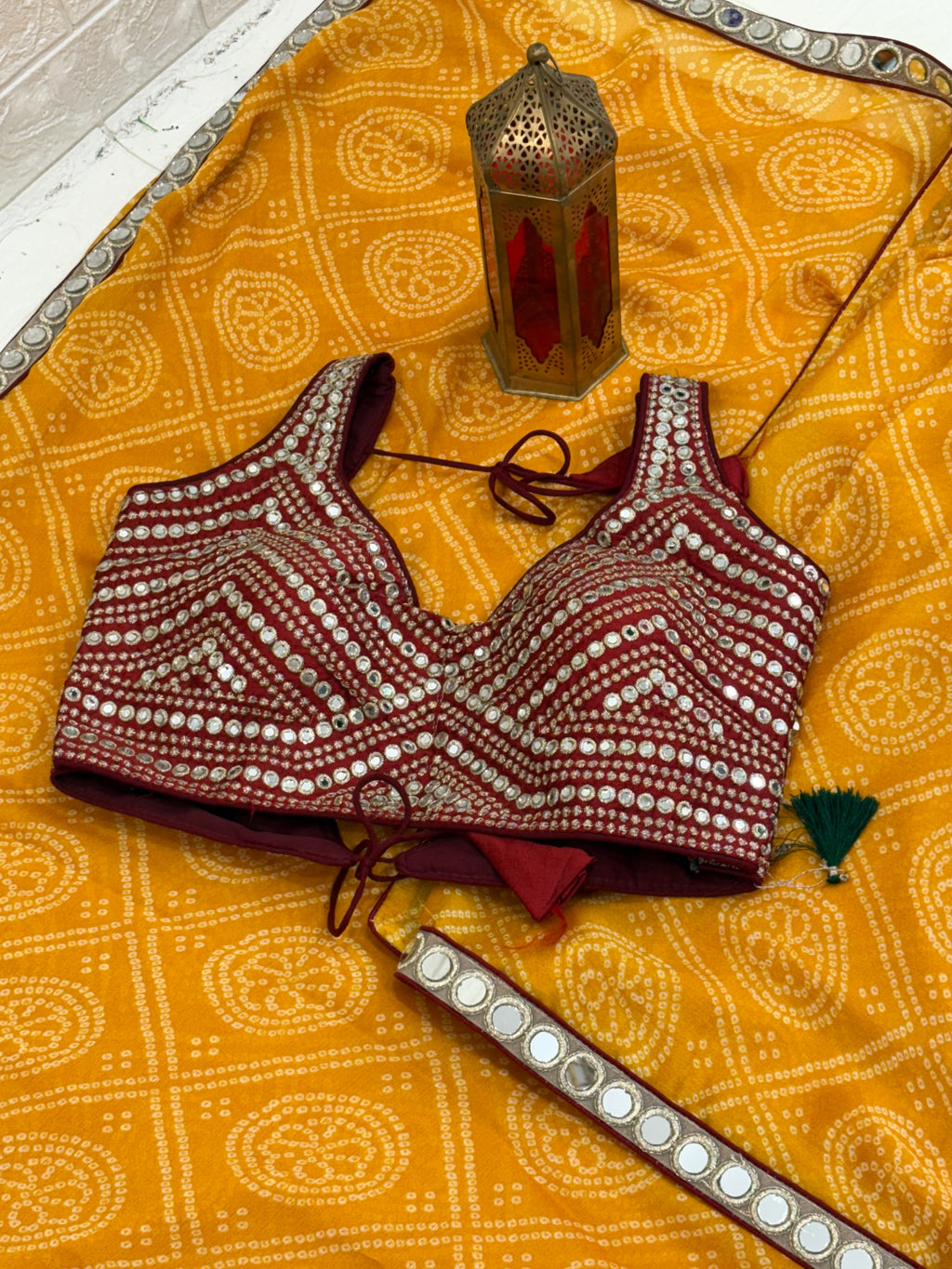 Bandhani print fabric crepe silk yellow colour saree blend with traditional tie-dye pattern and mirror-work maroon blouse embellishment