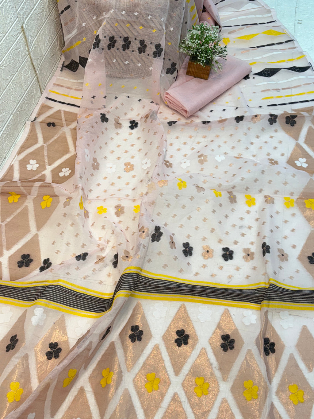 Pastel light pink Jamdani Saree cotton Jamdani, featuring geometric diamond motifs with delicate floral buttas and a soft, airy handwoven texture