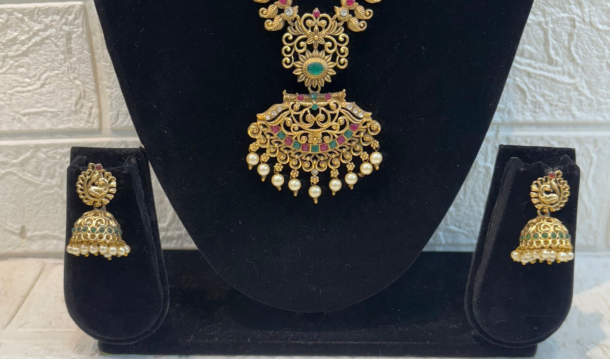 Traditional long haram featuring intricate motifs with ruby-green stone detailing and pearl drop pendant, paired with classic jhumka earrings—perfect for weddings and festive occasions.